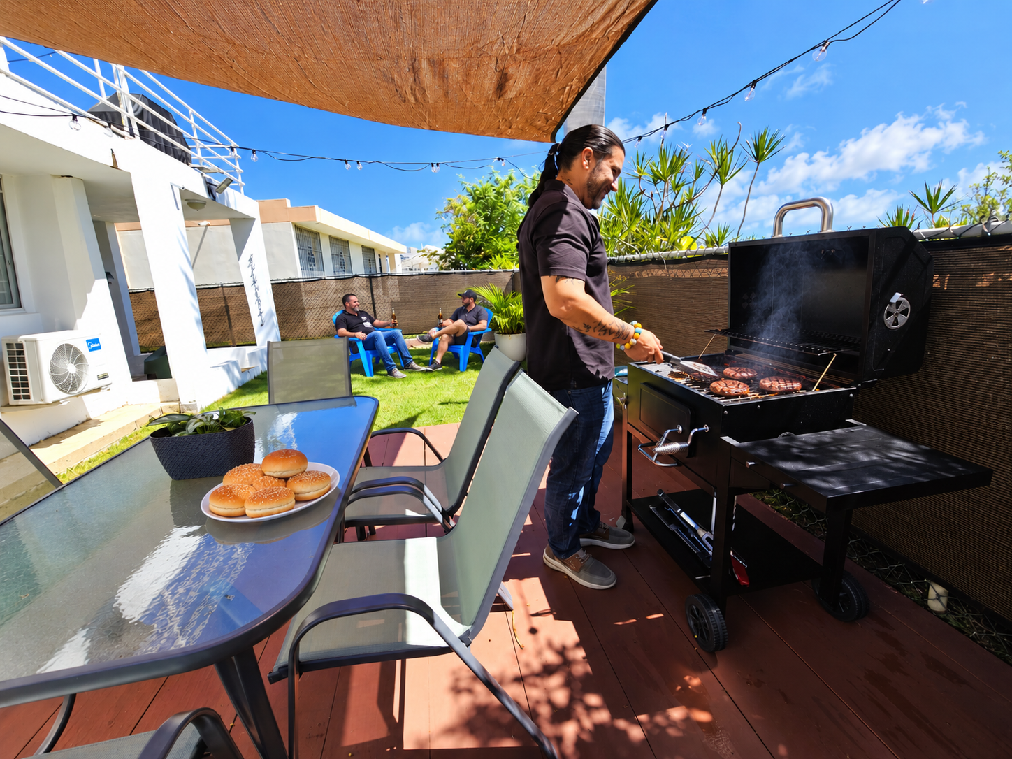 Sunny patio with BBQ grill, outdoor dining, and garden lounge space