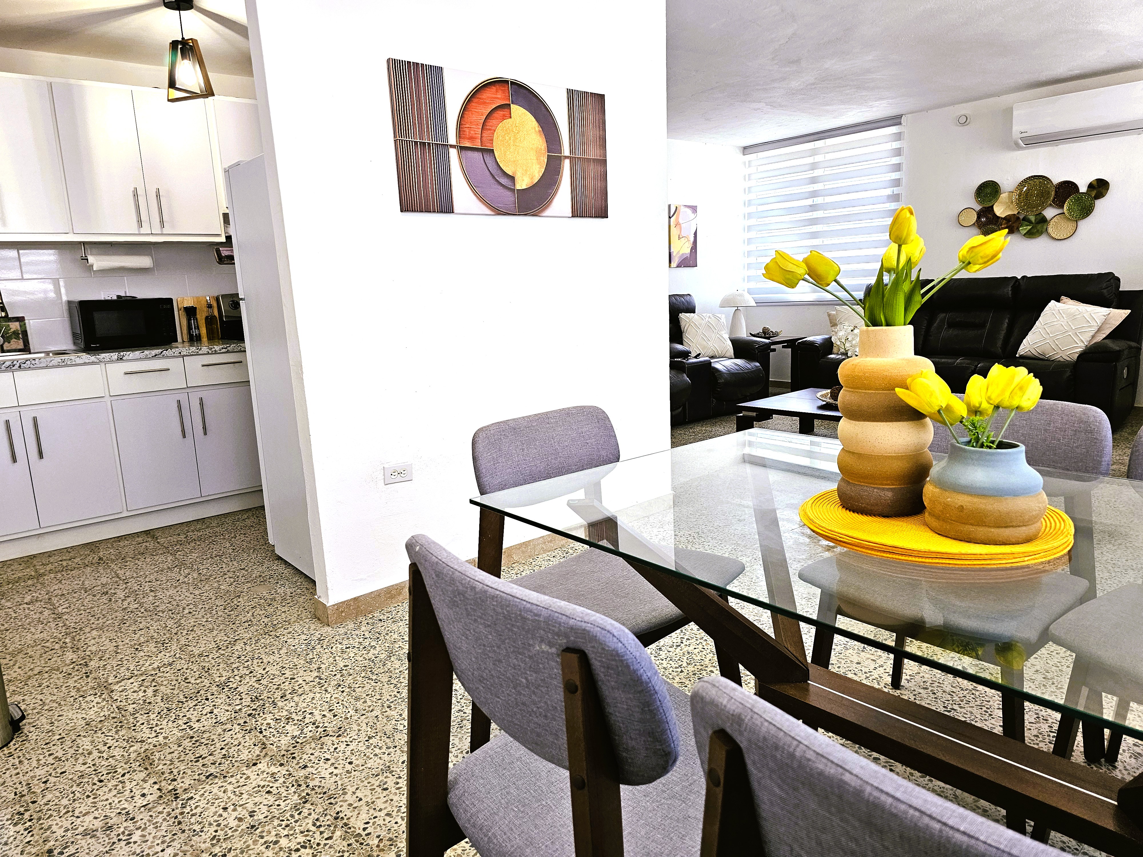 Bright open dining and living space with modern decor and full kitchen