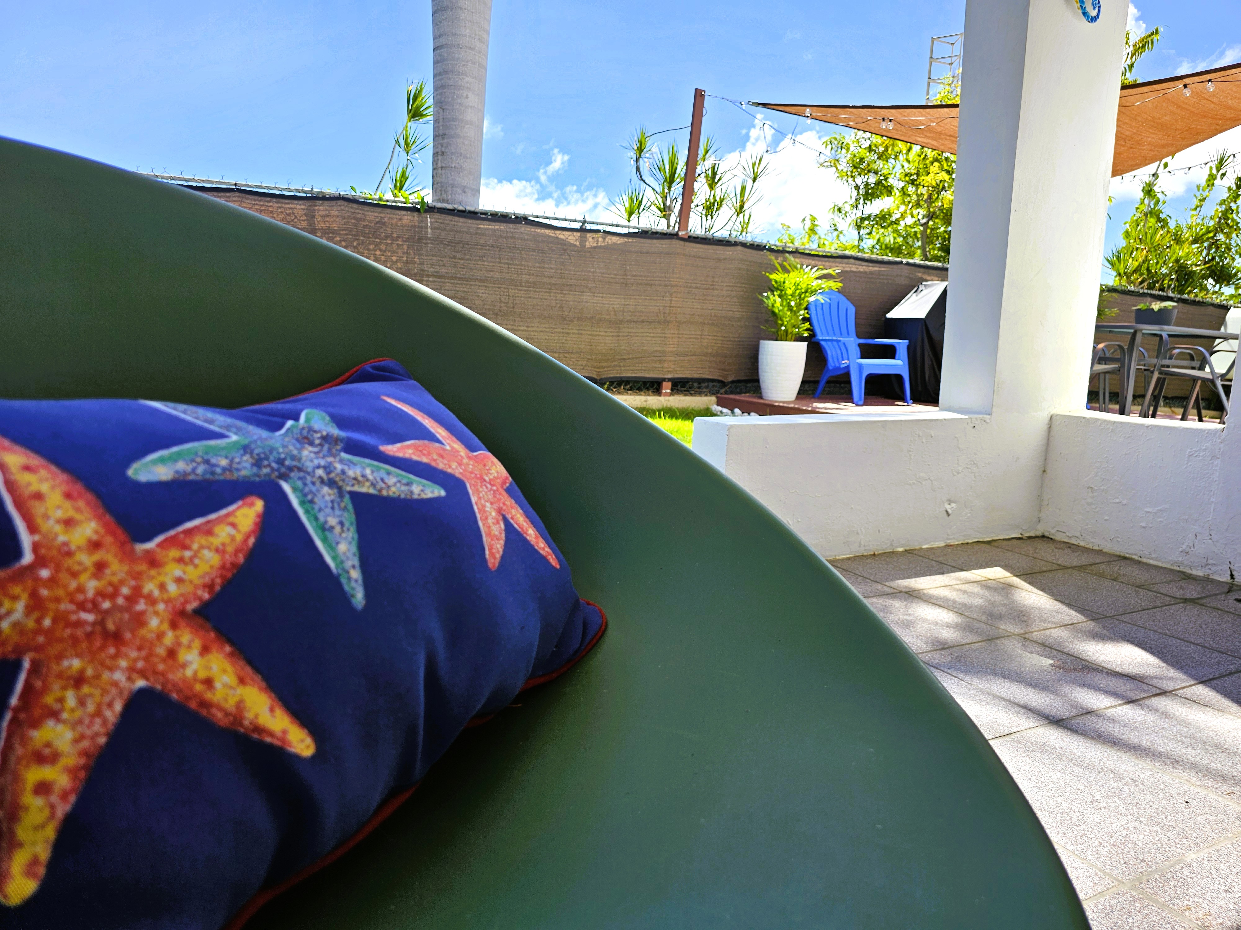 Sunny private patio with coastal accents and shaded outdoor seating