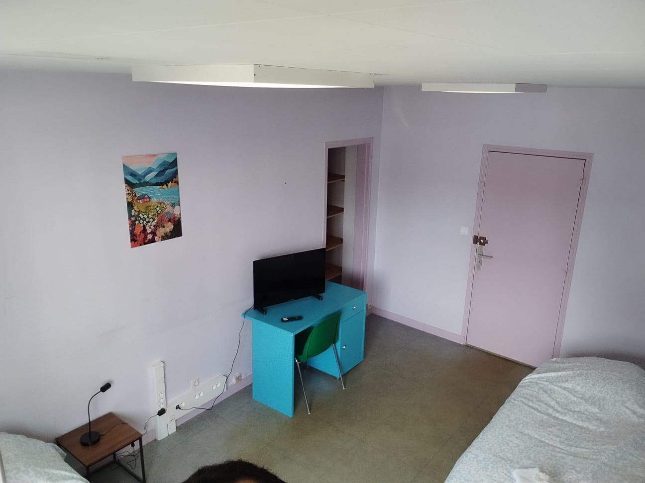 Bright twin room with desk, TV, and practical storage space