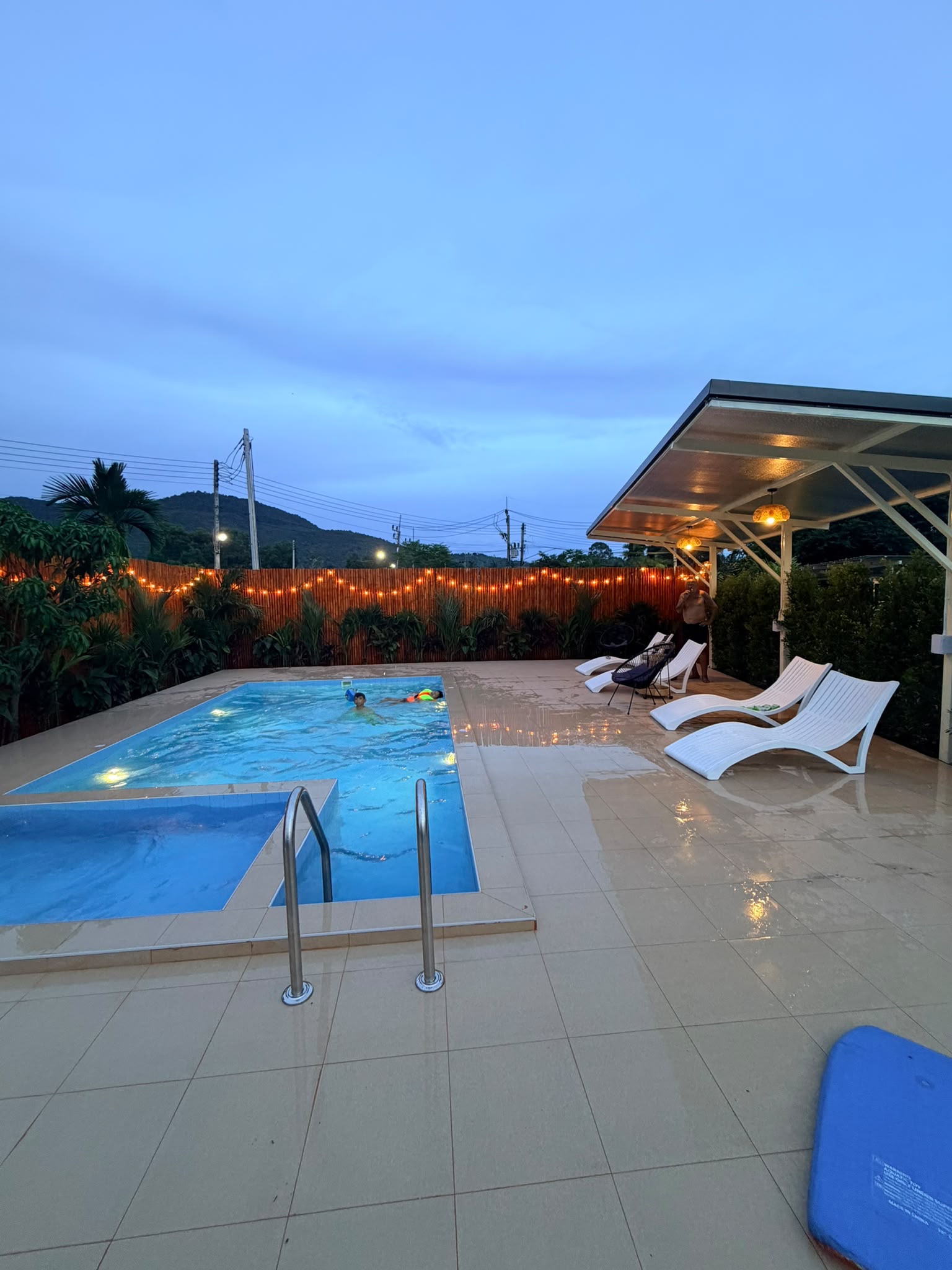 Private lit pool with stylish loungers and a cozy evening ambiance