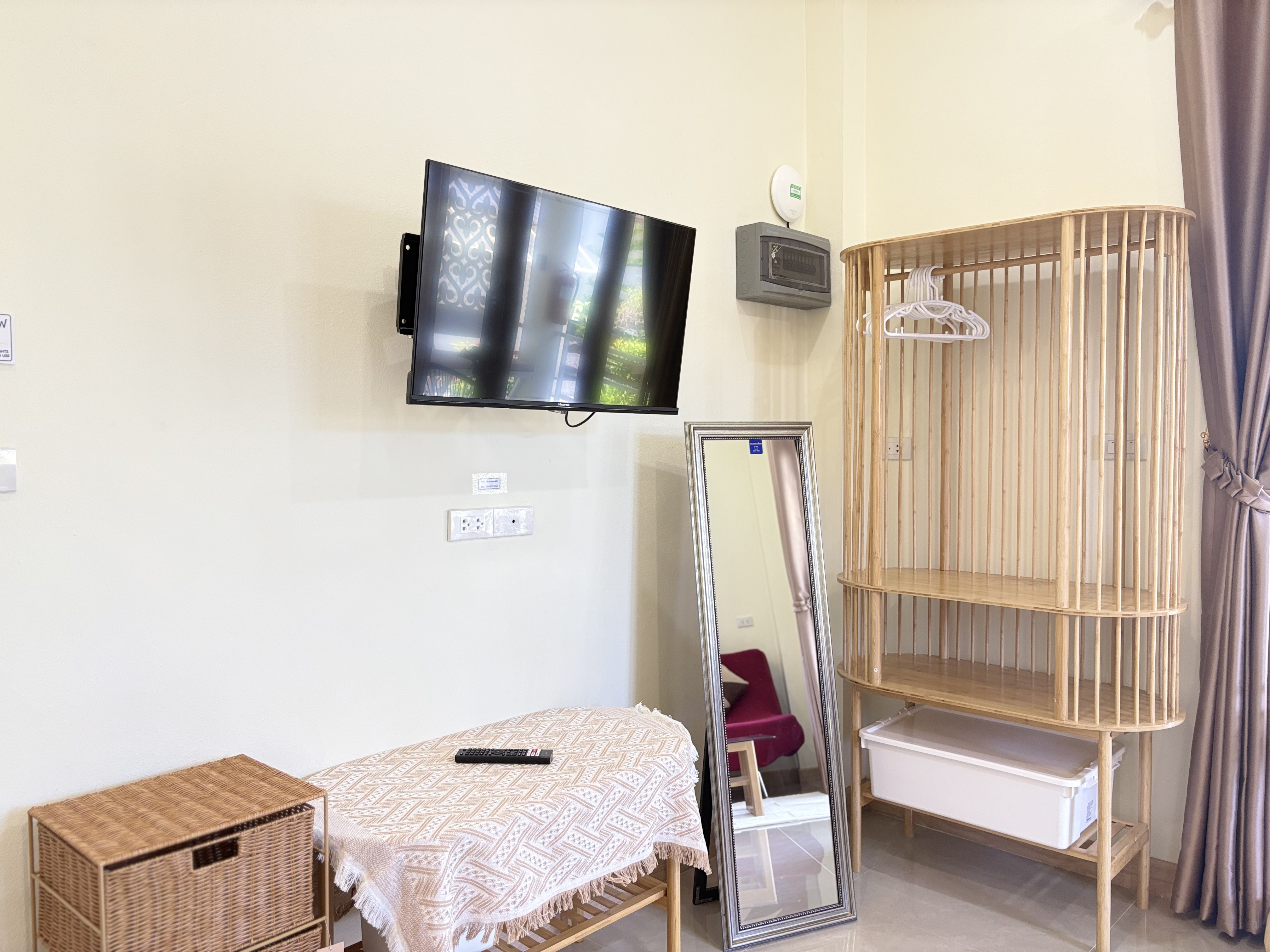 Bright corner with TV, full-length mirror, and stylish open wardrobe