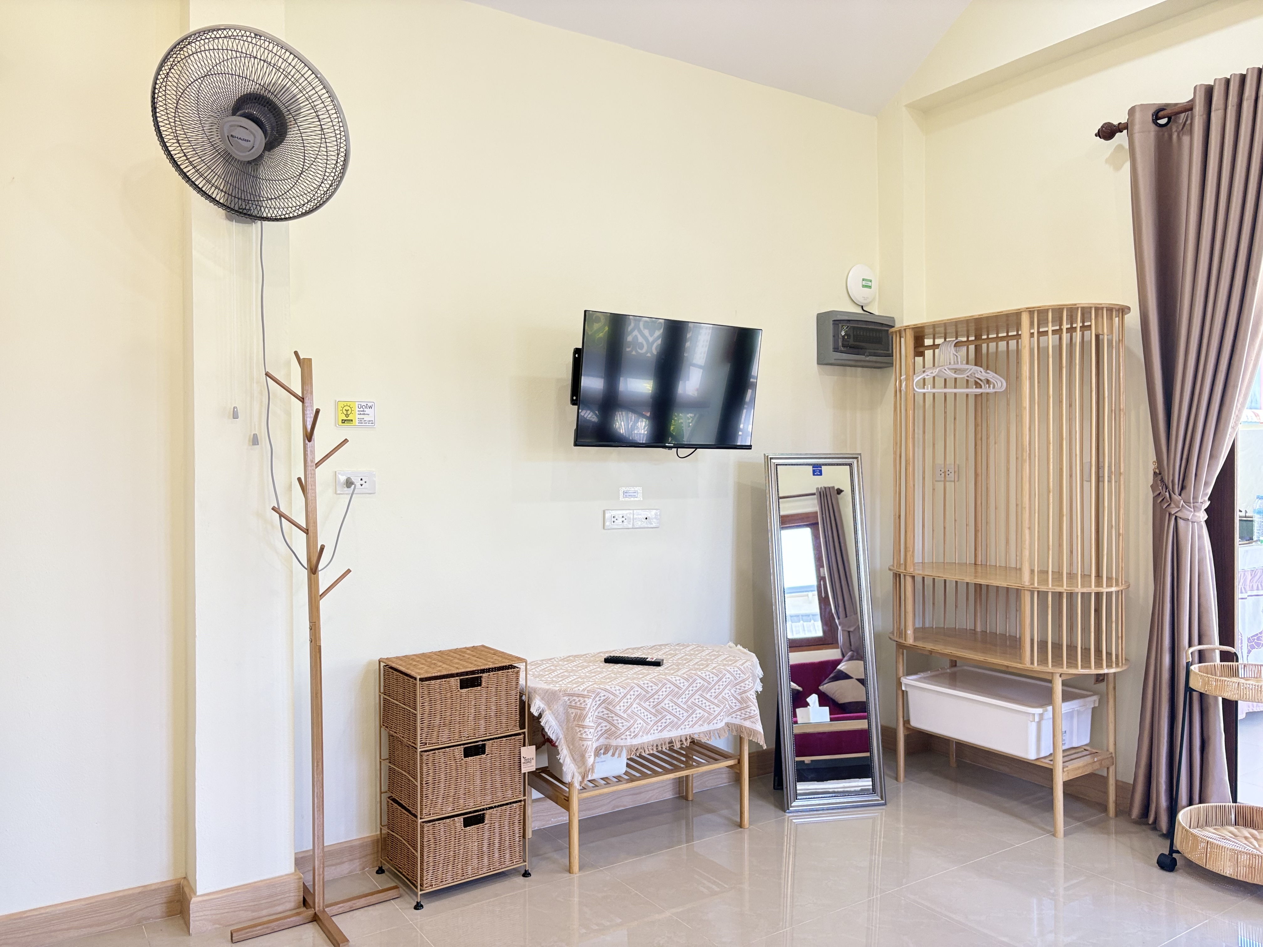 Bright airy room with TV, mirror, and open wardrobe storage