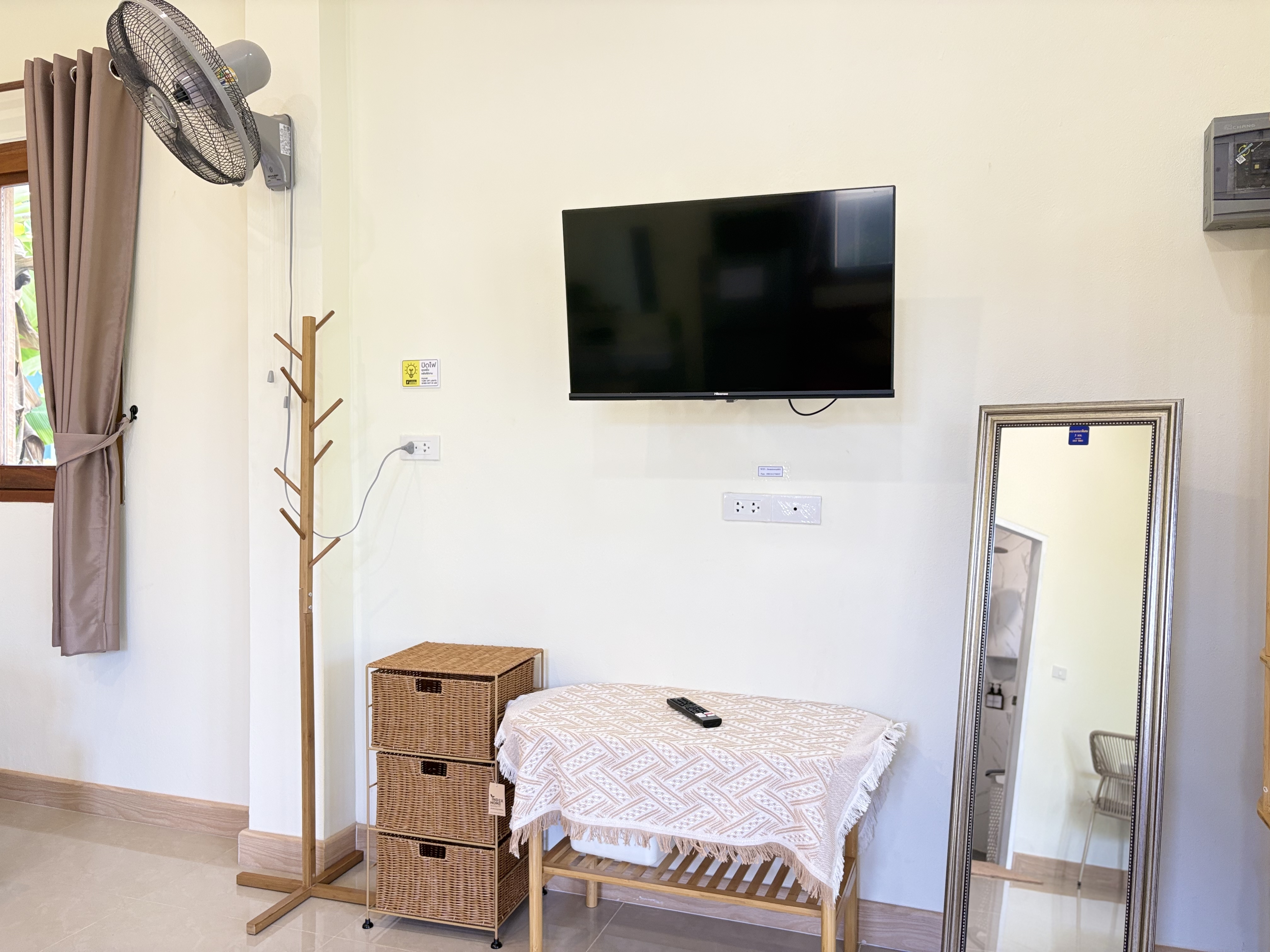 Bright room with TV, full-length mirror, fan, and handy storage