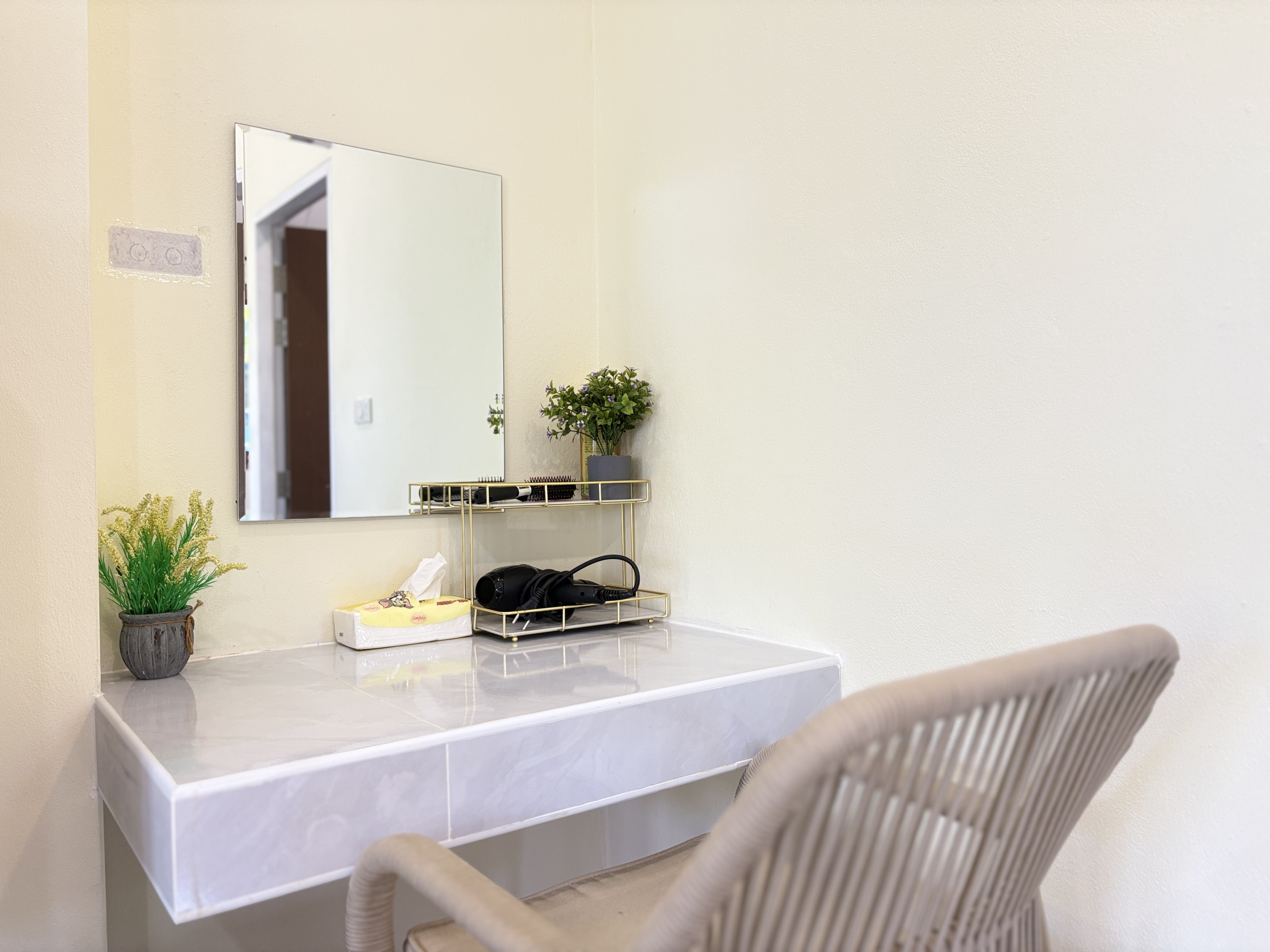 Bright vanity nook with mirror, chair, and clean modern styling