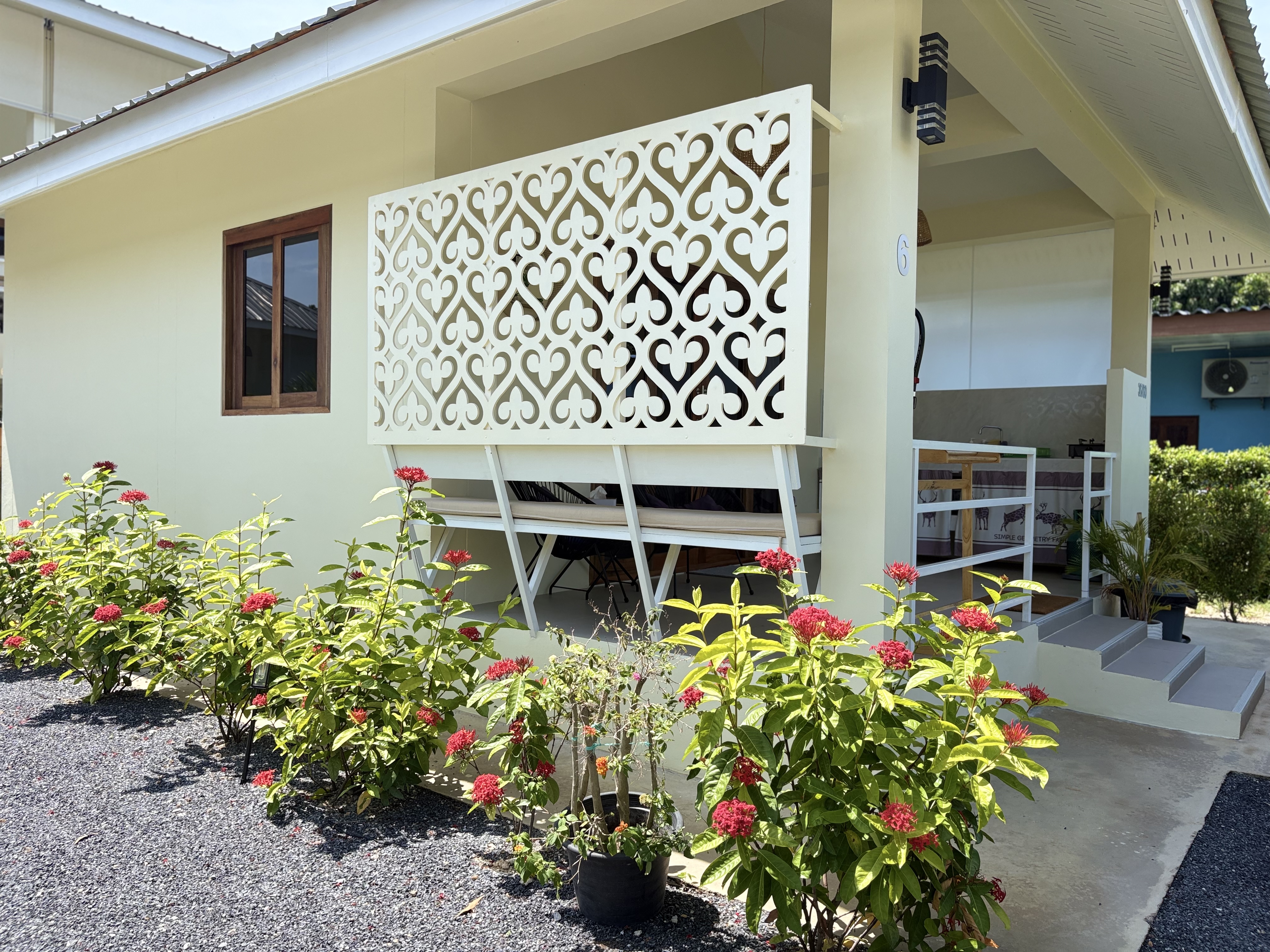 Charming covered patio with privacy screen and lush flowering garden