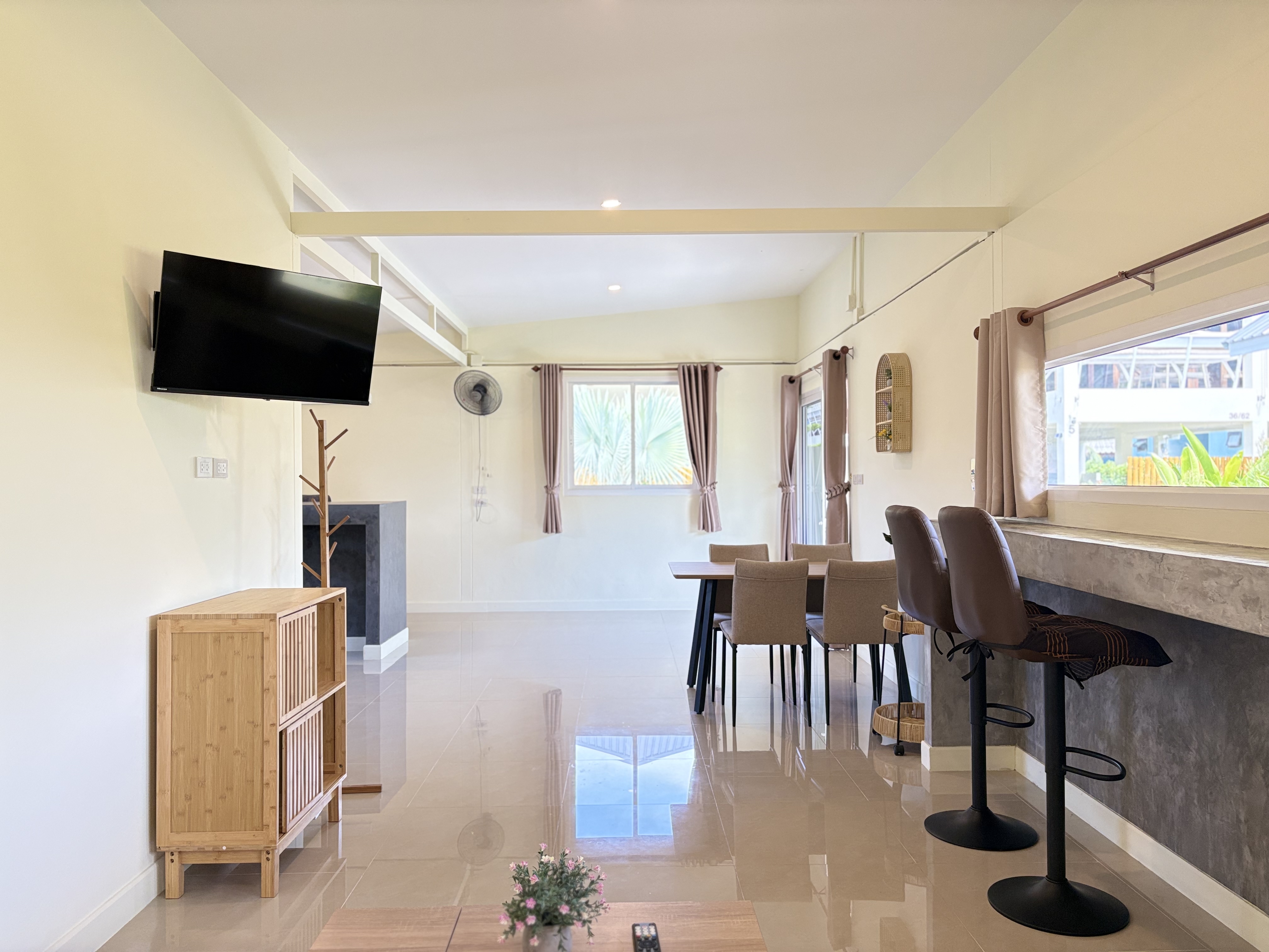 Bright open-plan living with dining area, breakfast bar, and natural light