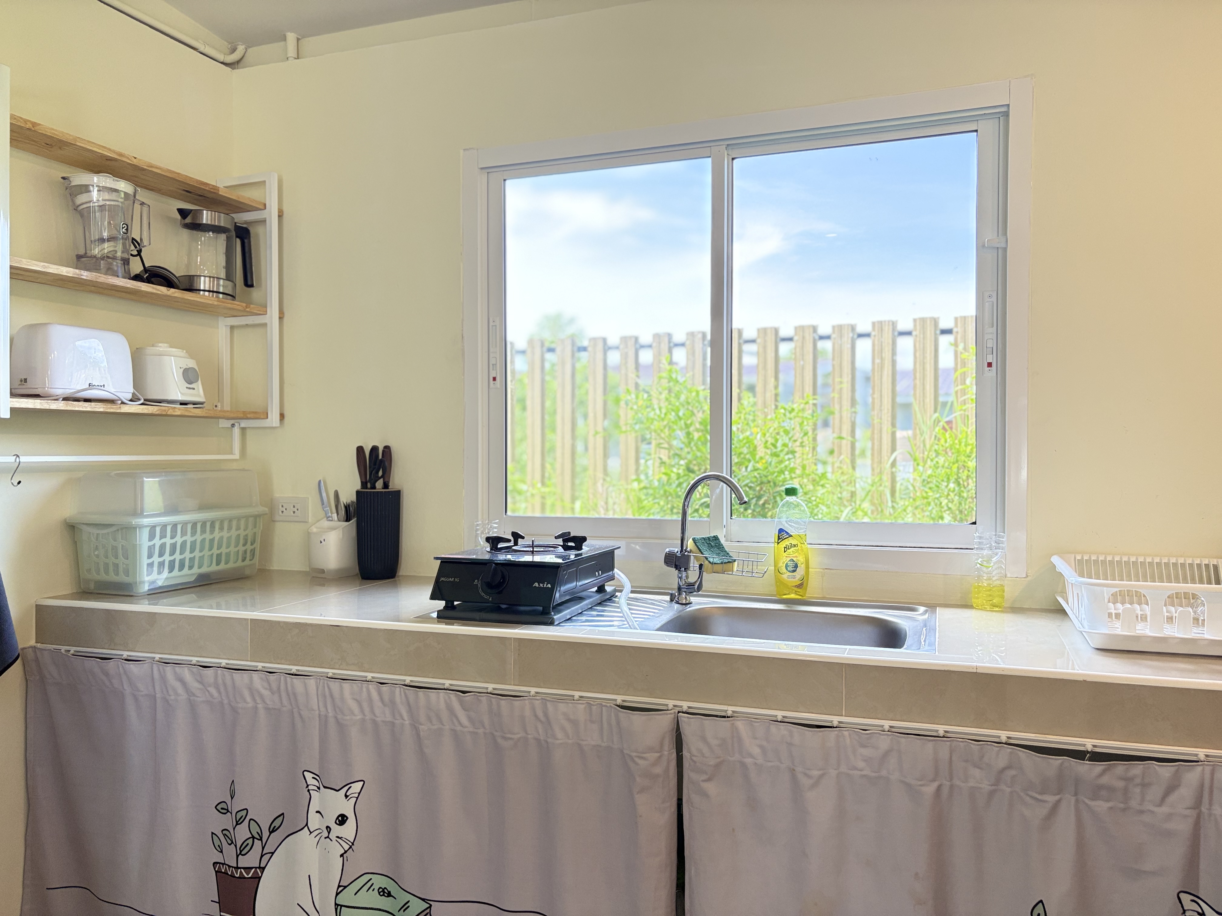 Bright kitchenette with garden-view window and handy cooking essentials