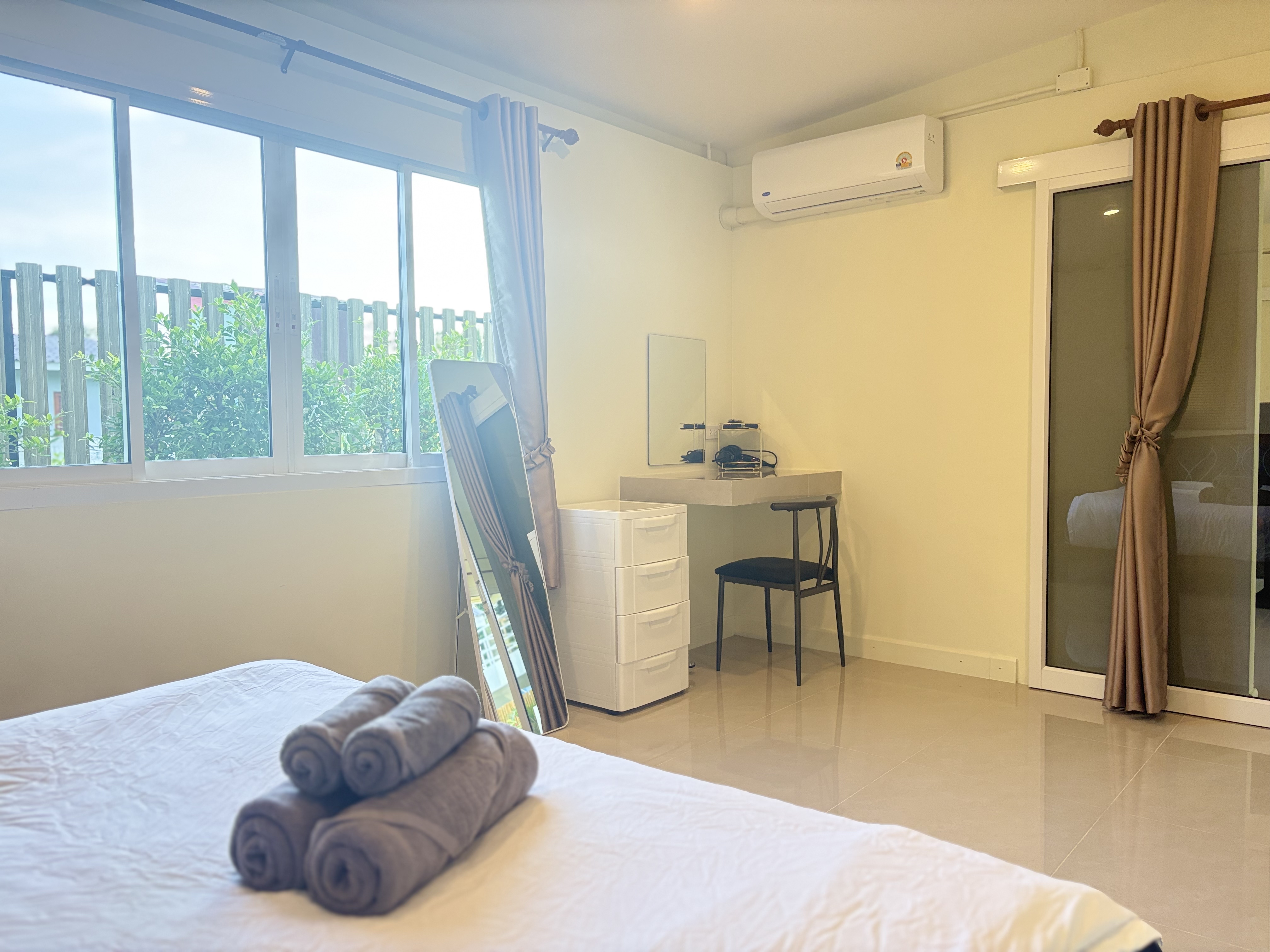 Bright, airy bedroom with AC, workspace, and garden-view windows