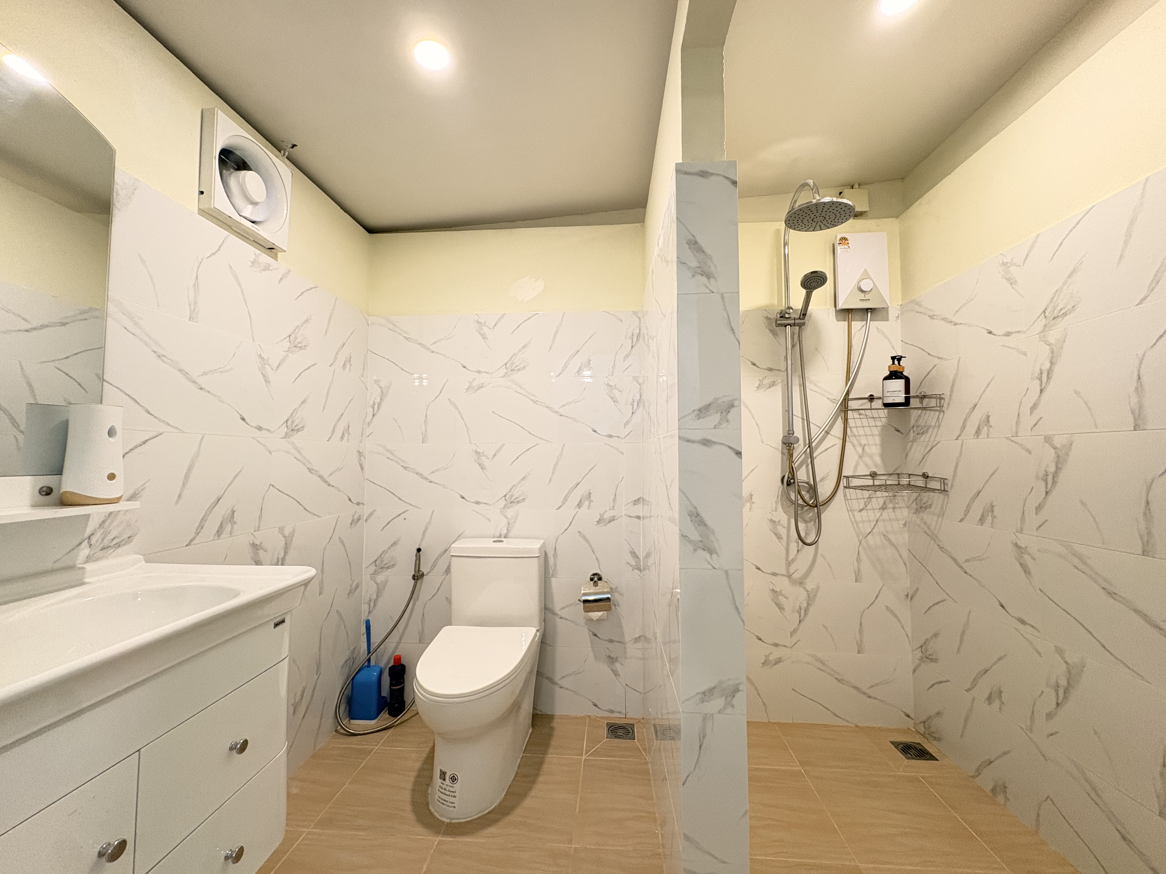 Bright modern bathroom with marble-look tile and spacious rainfall shower