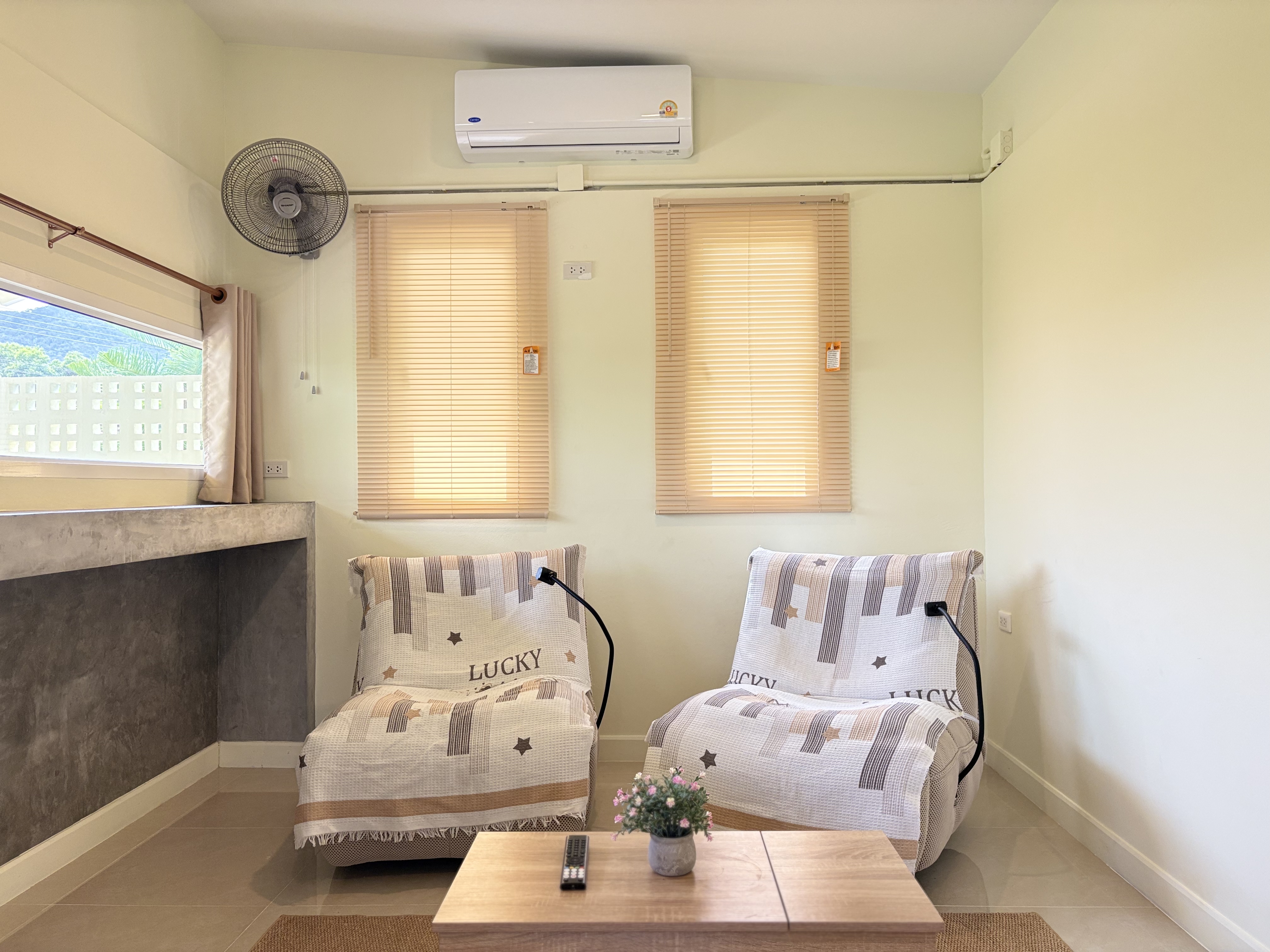 Bright lounge corner with AC, comfy seating, and plenty of natural light