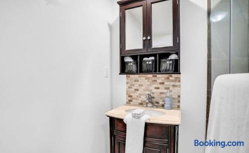 Stylish bathroom vanity with mosaic tile, glass shower, and guest-ready storage