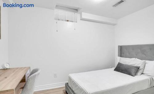 Bright minimalist bedroom with workspace and plush upholstered bed