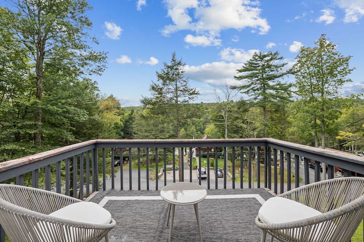 Peaceful treetop balcony with cozy seating and serene wooded views