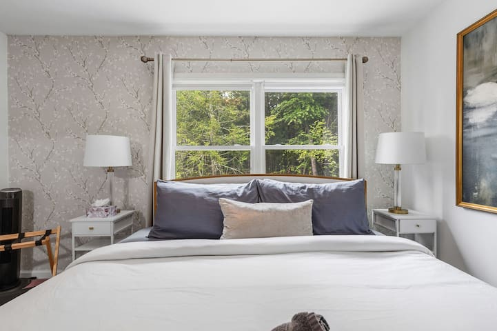 Bright, serene bedroom with large window and peaceful treetop views