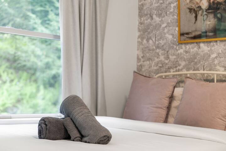 Bright, cozy bedroom with garden views and elegant finishing touches
