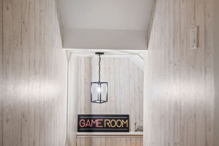 Charming wood-lined hallway leading to a fun, inviting game room
