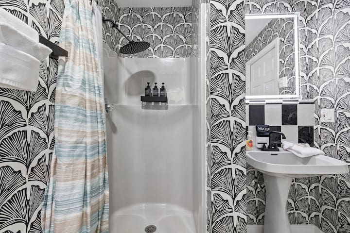 Stylish bathroom with rainfall shower and bold designer wallpaper