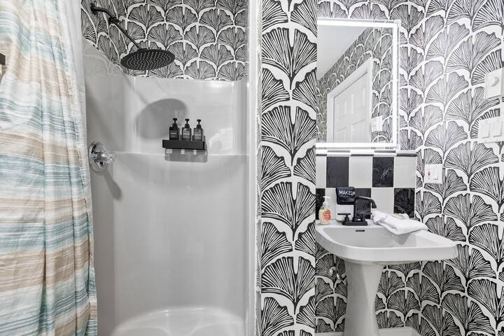 Chic bathroom with rainfall shower and bold designer wallpaper