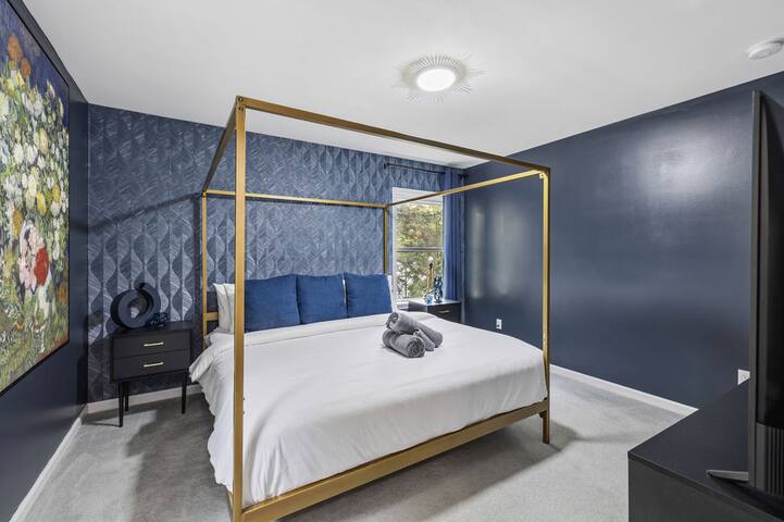 Elegant navy bedroom with gold canopy bed and boutique-style design