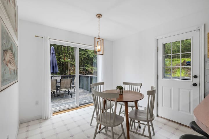 Bright dining nook with deck access and peaceful wooded views