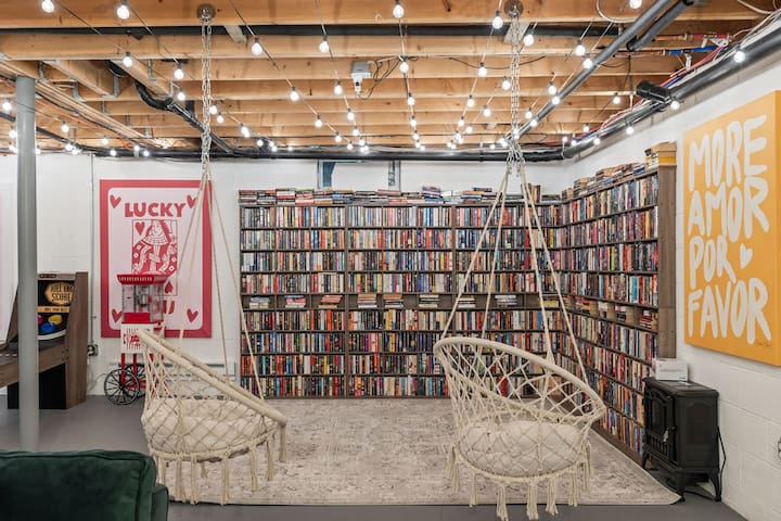 Cozy library lounge with swing chairs, warm lights, and bold artistic flair