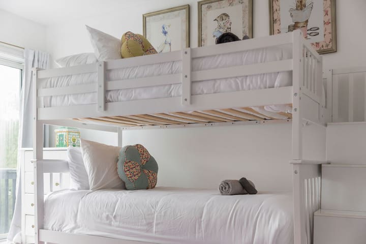 Bright bunk room with stylish decor and built-in stairs for easy access
