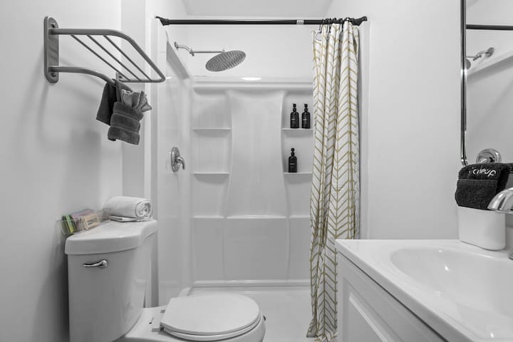 Bright modern bathroom with rain shower and fresh guest-ready touches