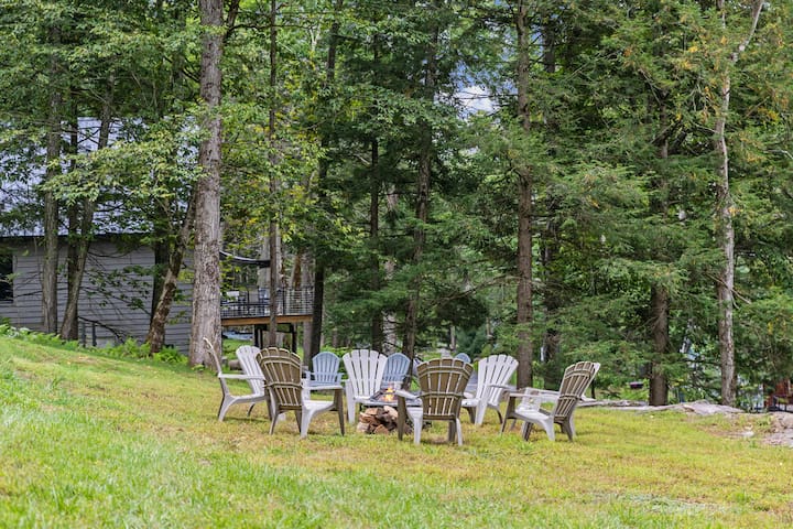 Wooded lawn with Adirondack fire pit seating for cozy outdoor evenings