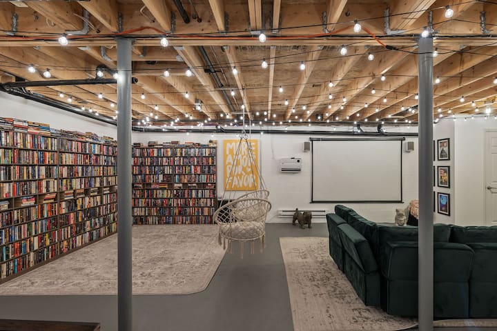 Cozy library lounge with projector screen and ambient string lights