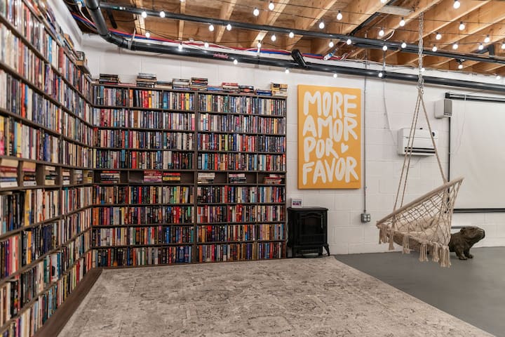 Floor-to-ceiling library with string lights and a cozy hammock nook