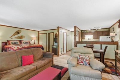 Cozy cabin-style studio with full kitchen, dining nook, and comfy seating