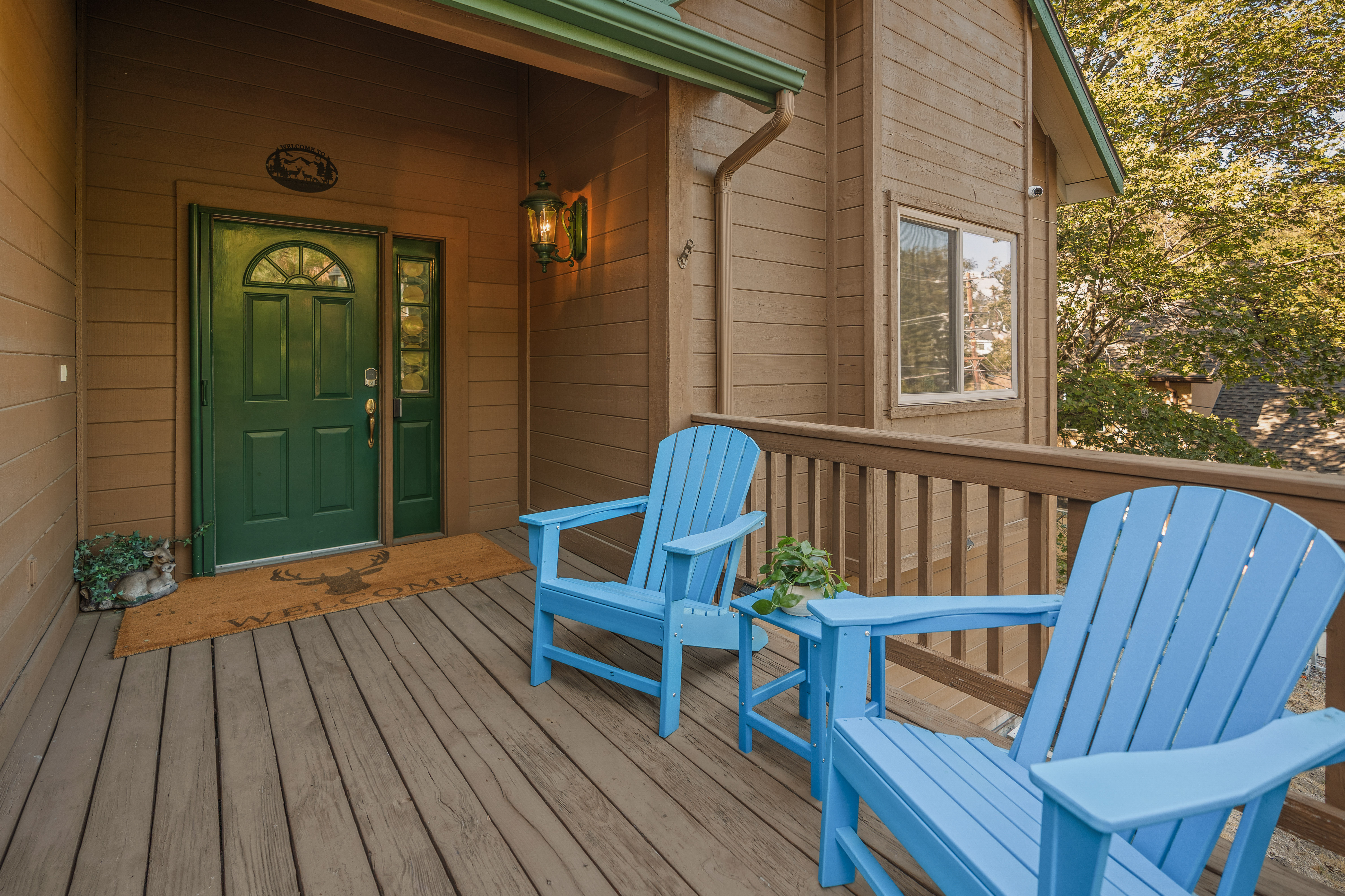 Welcoming covered porch with blue Adirondack chairs and rustic charm