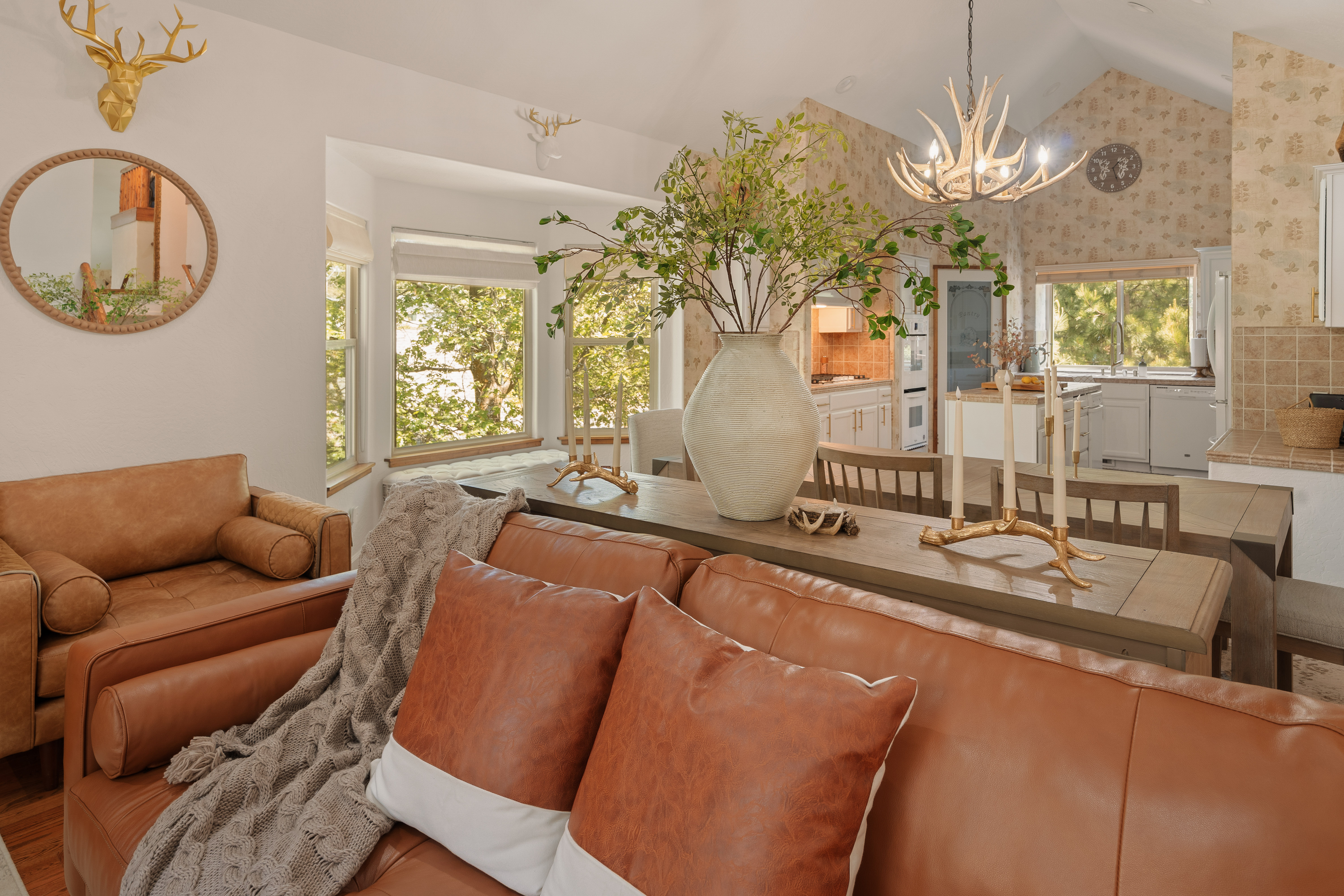 Bright rustic-chic living space with leather seating and sunny open kitchen