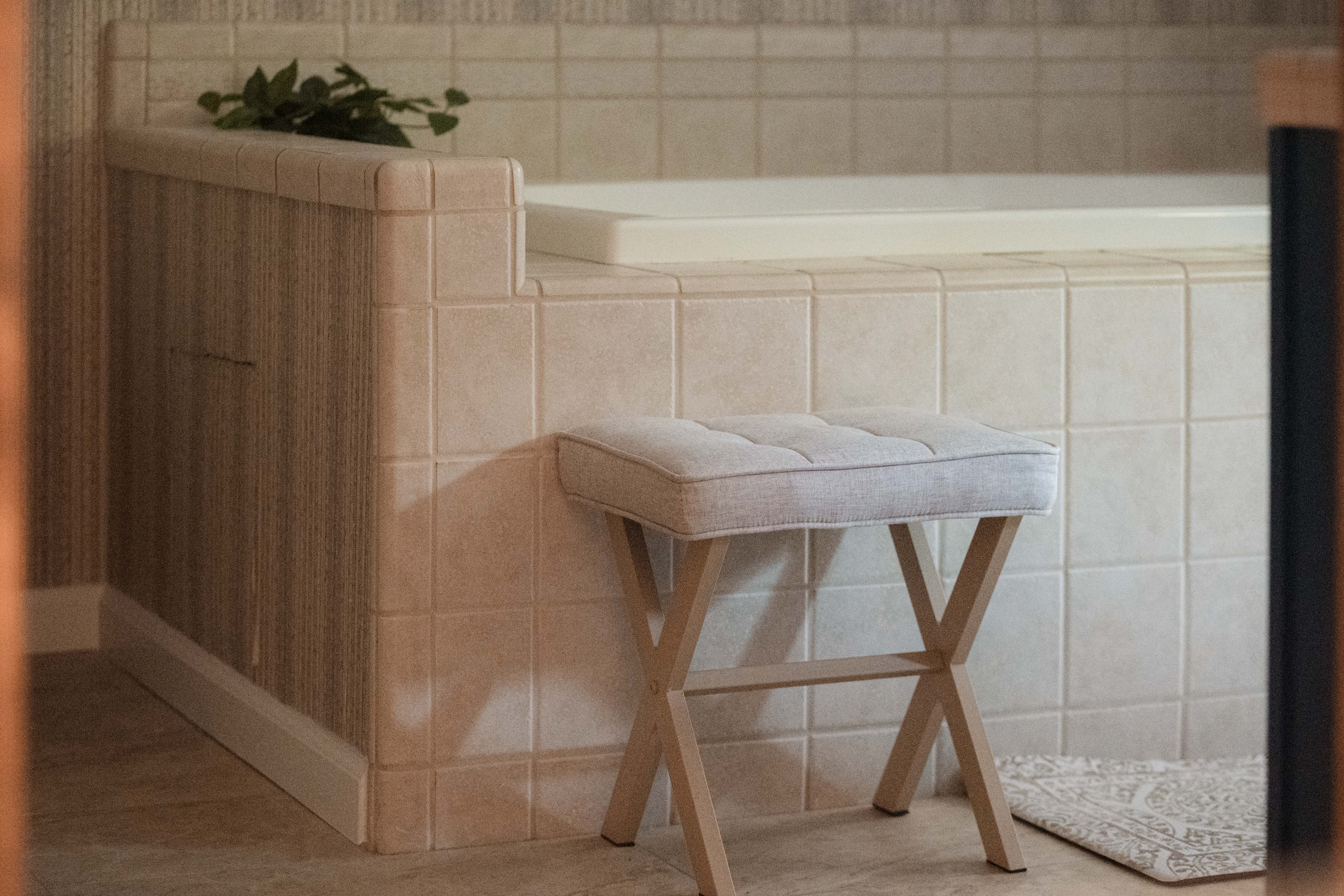Spa-like soaking tub with elegant tile and a cozy seating bench