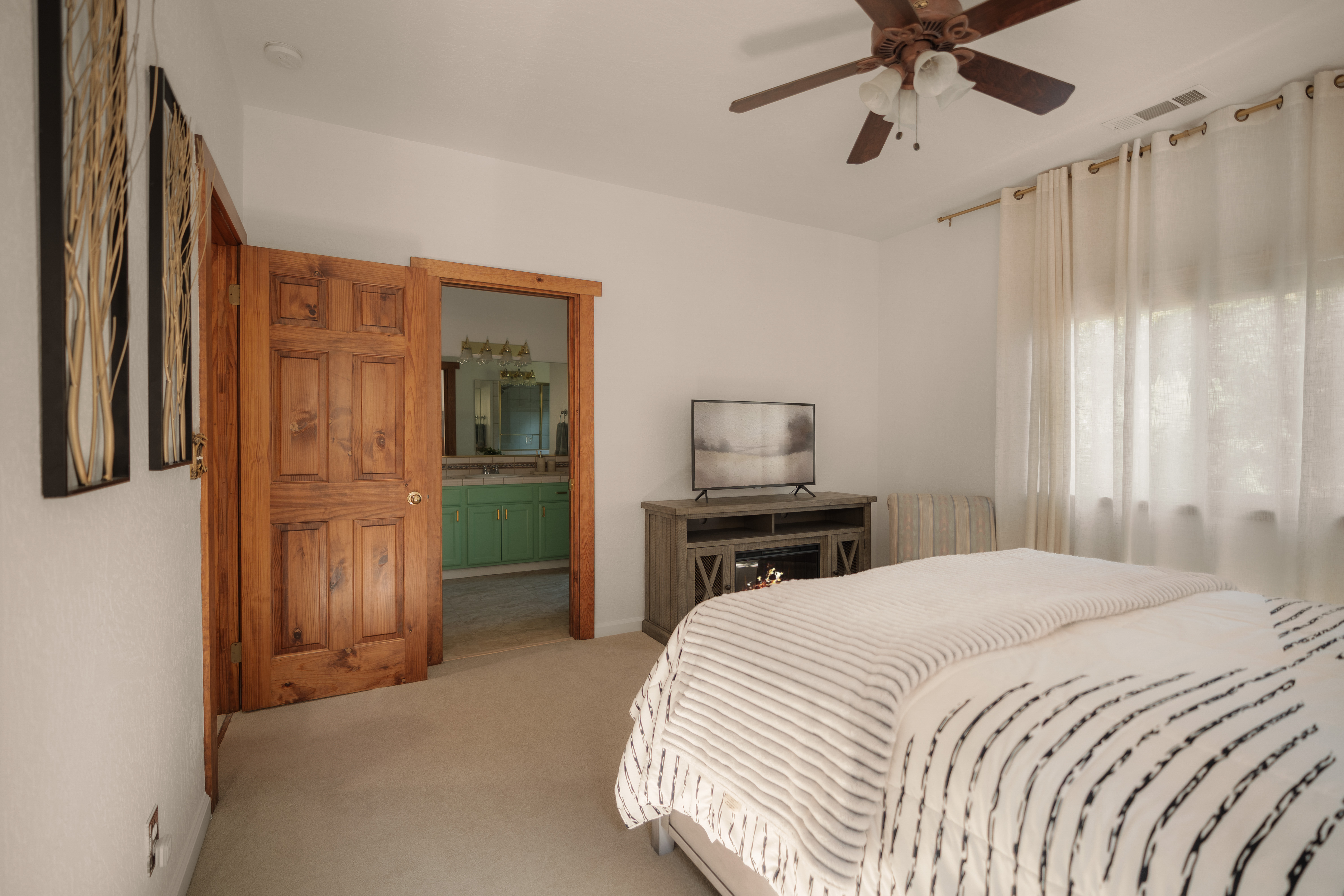 Bright, spacious bedroom with en suite bath, TV, and warm rustic touches