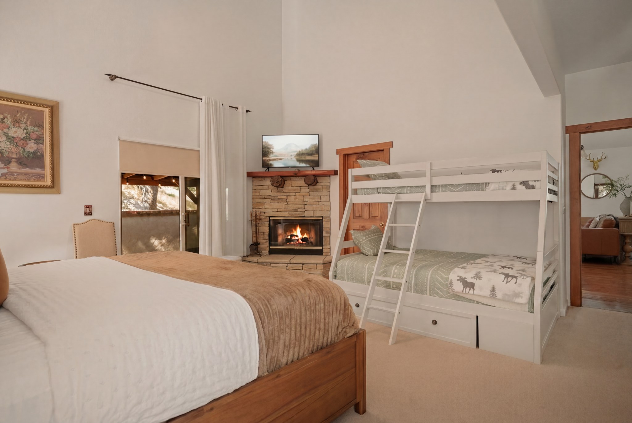 Spacious family bedroom with fireplace, bunks, and cozy cabin charm