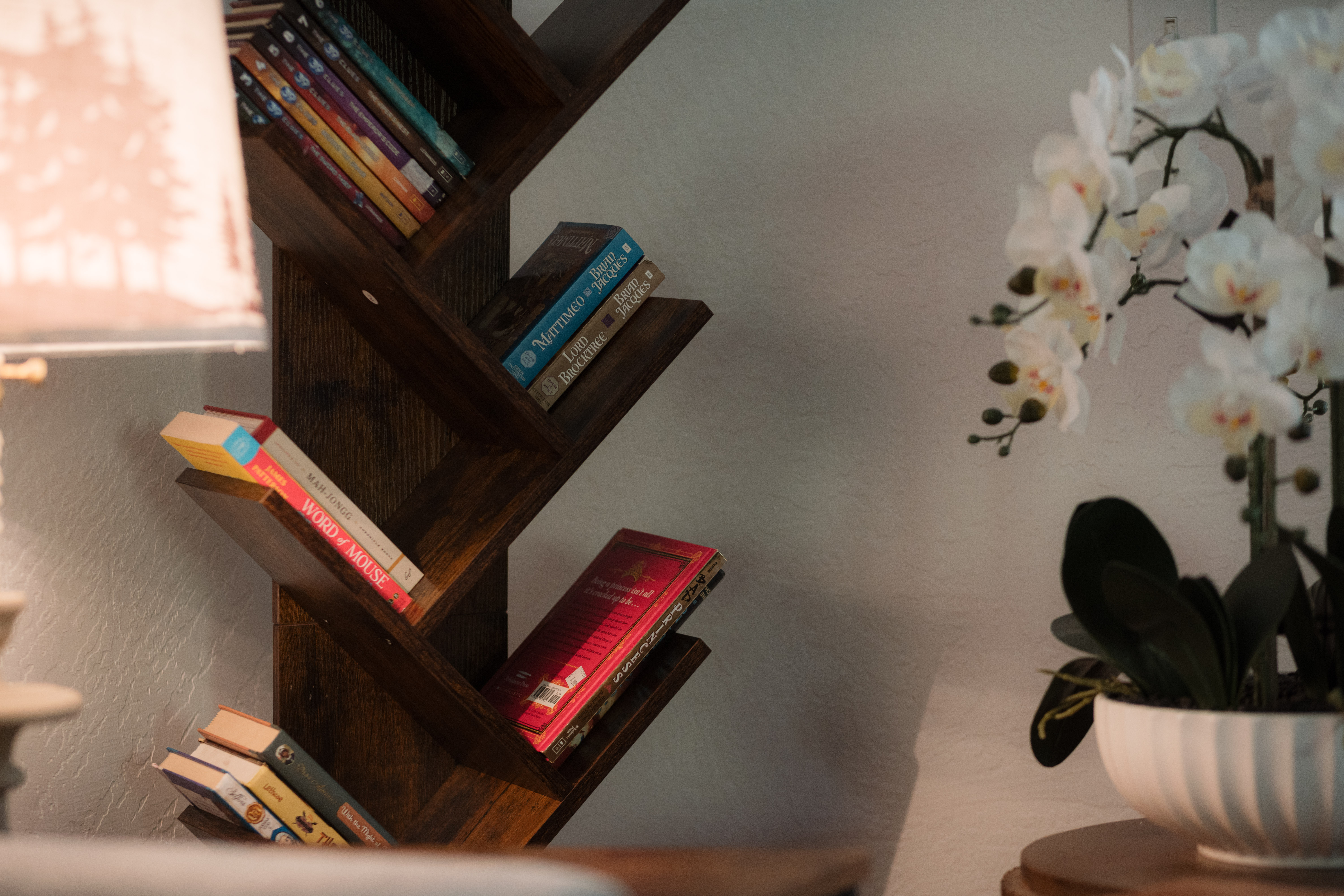 Cozy reading nook with designer shelving and elegant orchid decor