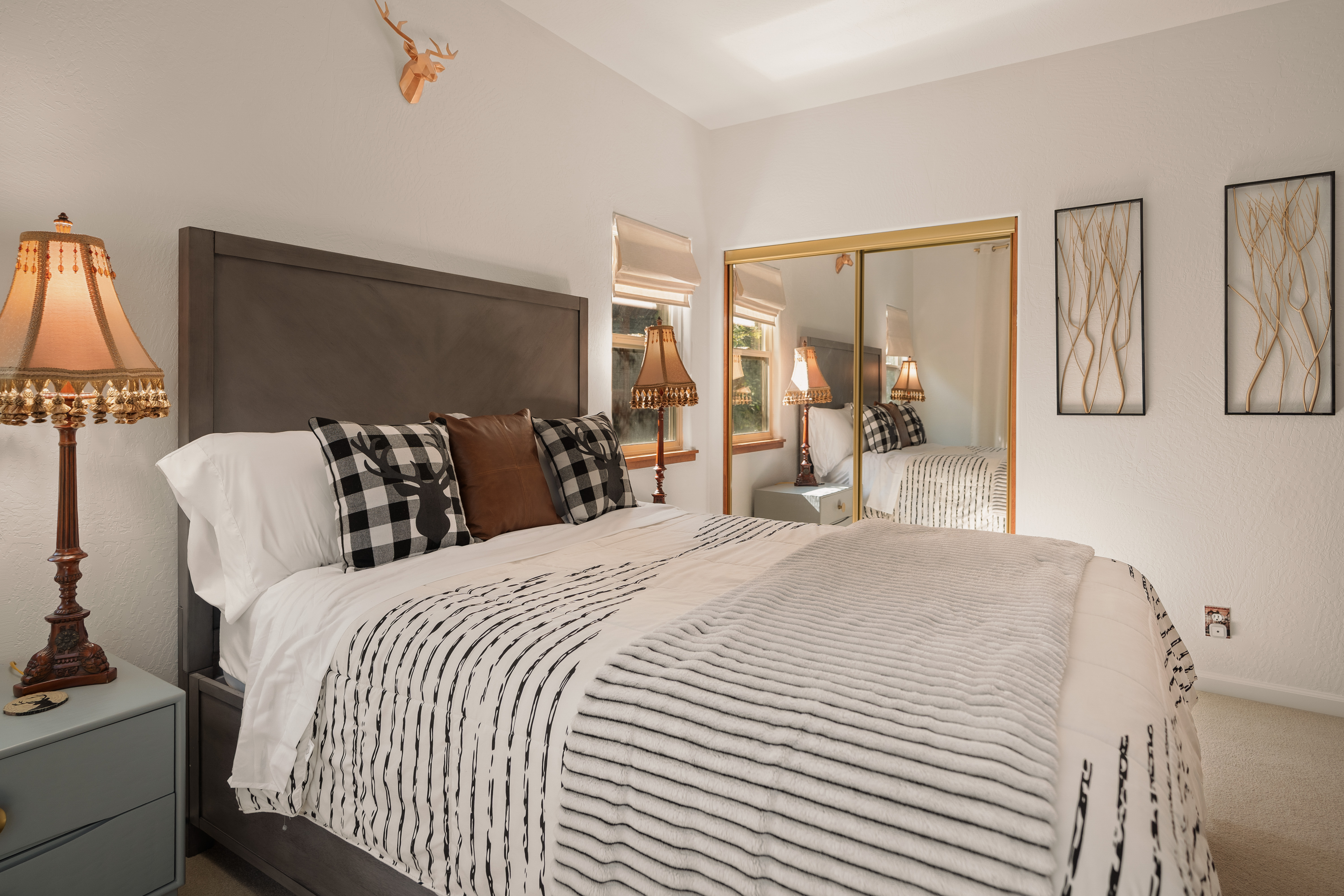Cozy, stylish bedroom with mirrored closets and warm ambient lighting