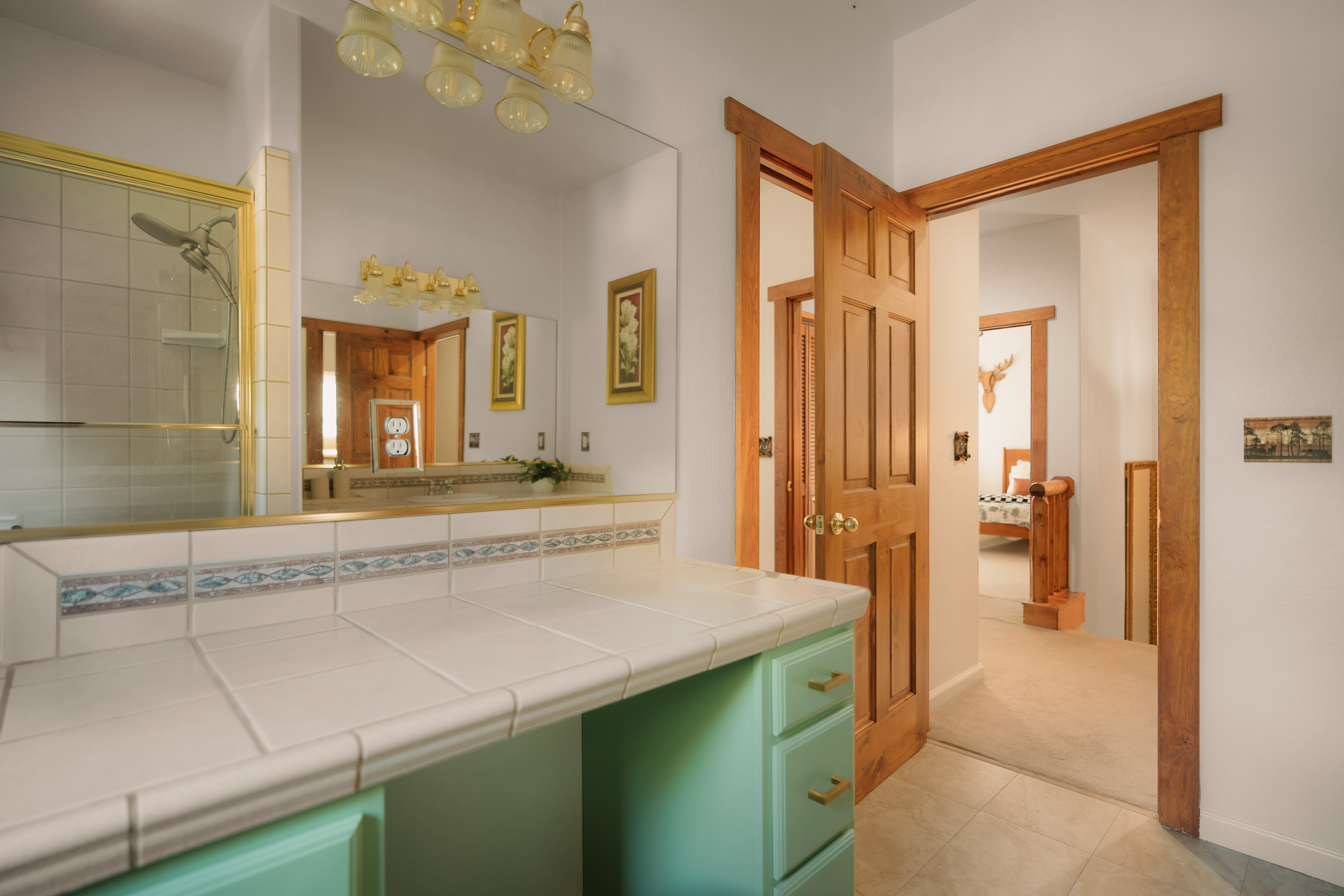 Bright tiled bathroom with glass shower and charming wood accents