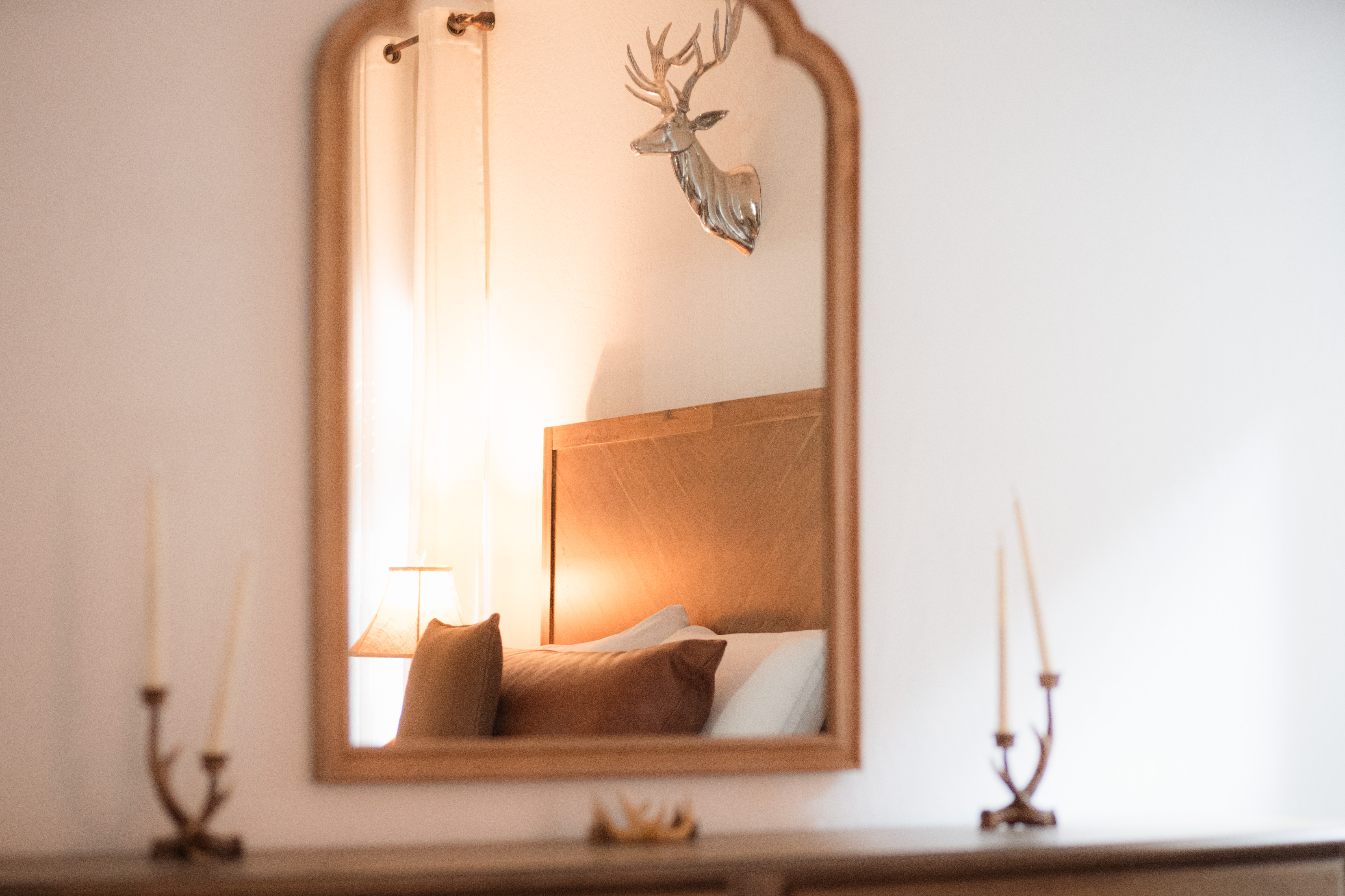 Cozy bedroom glow with rustic touches and elegant mirror detail