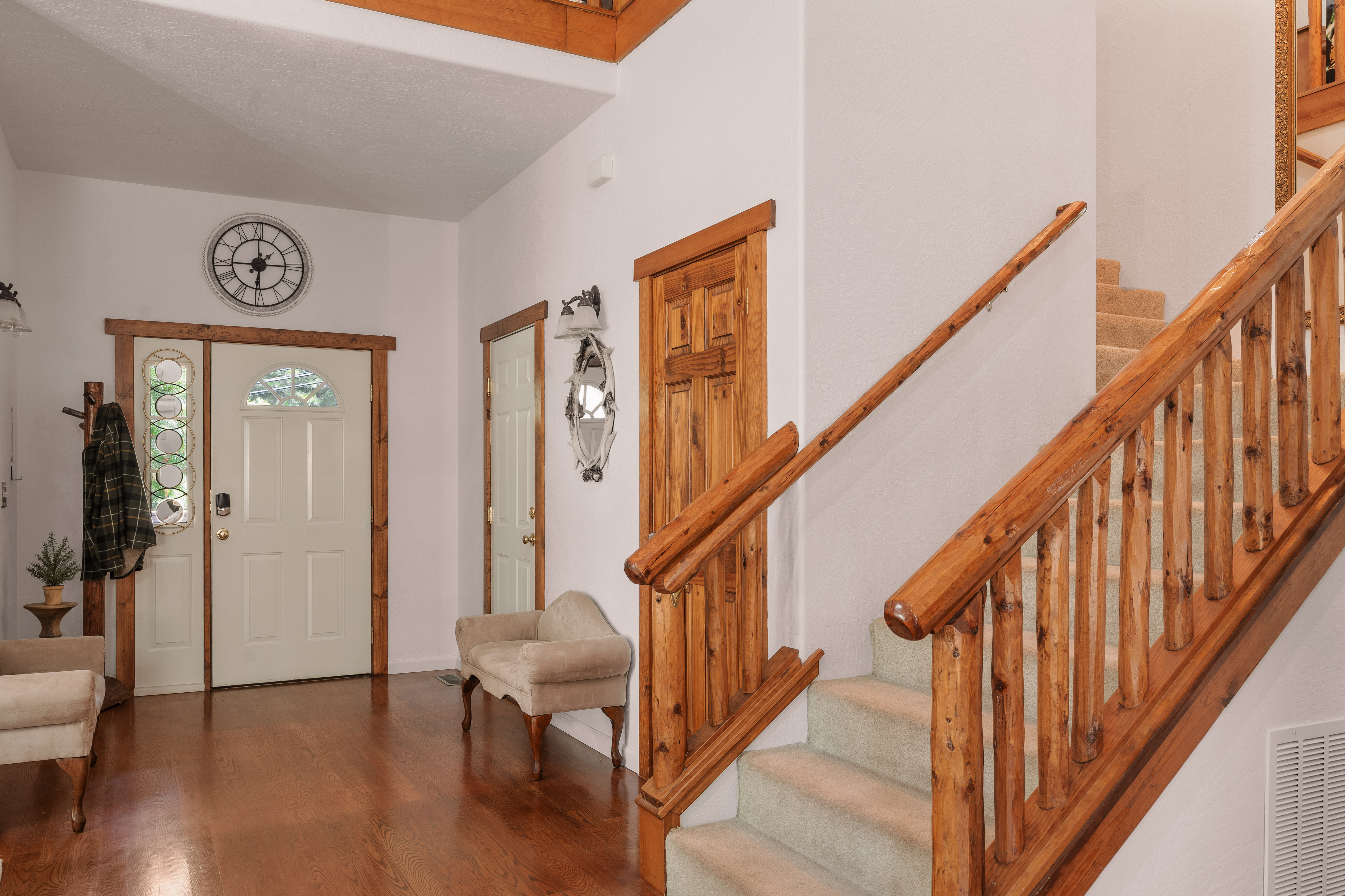 Grand entryway with soaring ceilings and beautiful rustic wood staircase