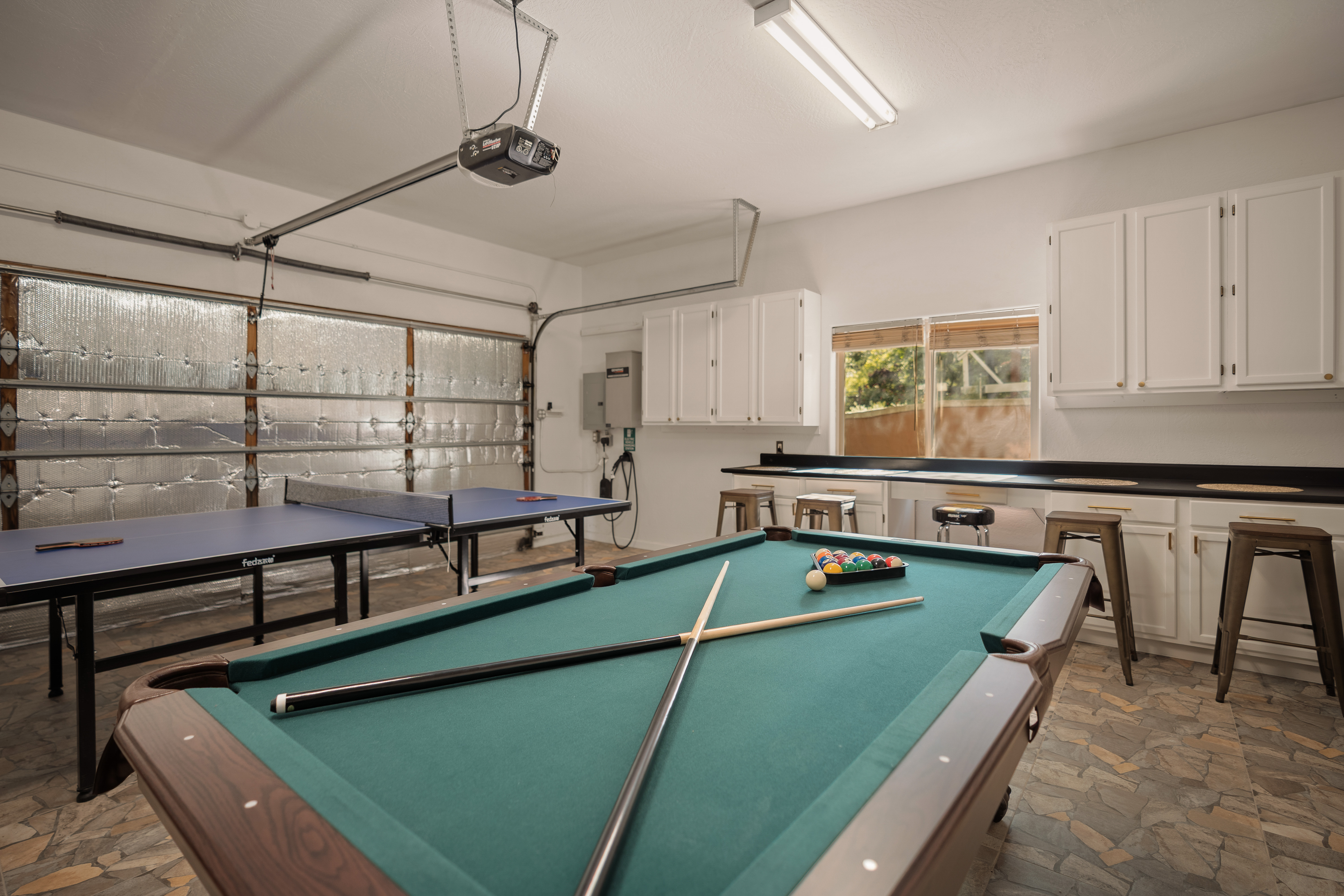 Fun-filled game room with pool, ping pong, and bar seating