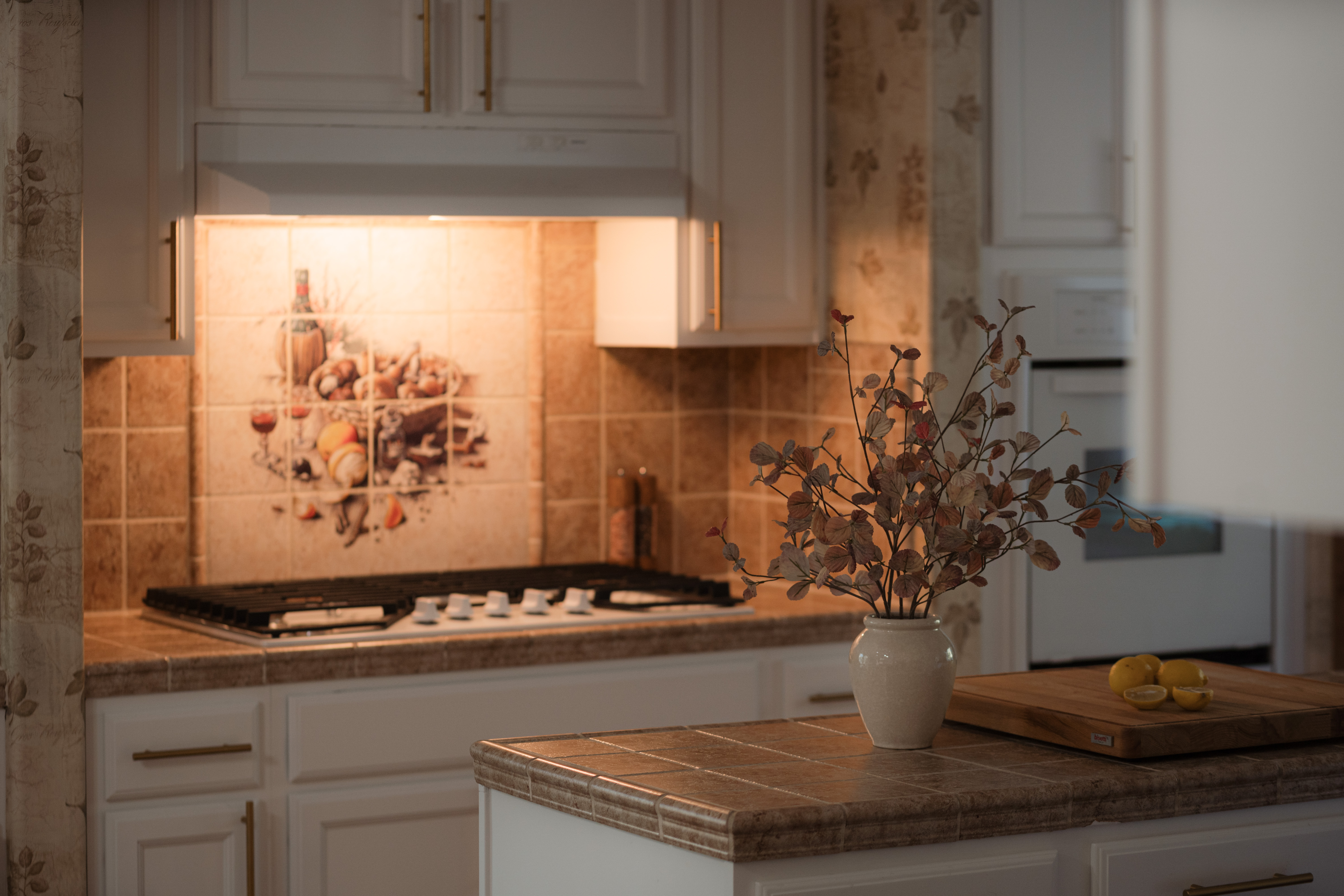Cozy, well-lit kitchen with charming tile details and island workspace