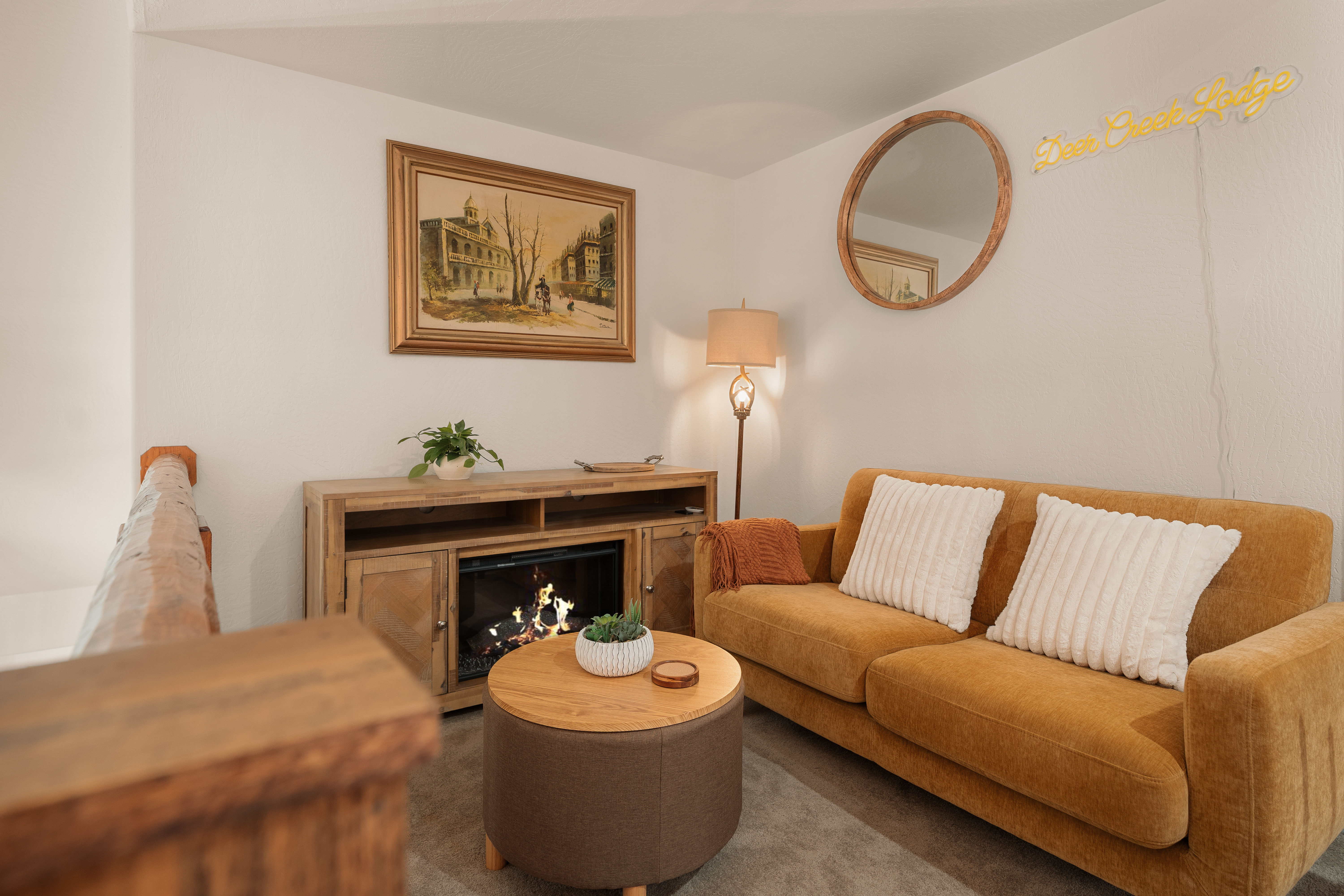 Cozy lounge with fireplace, stylish sofa, and warm rustic charm