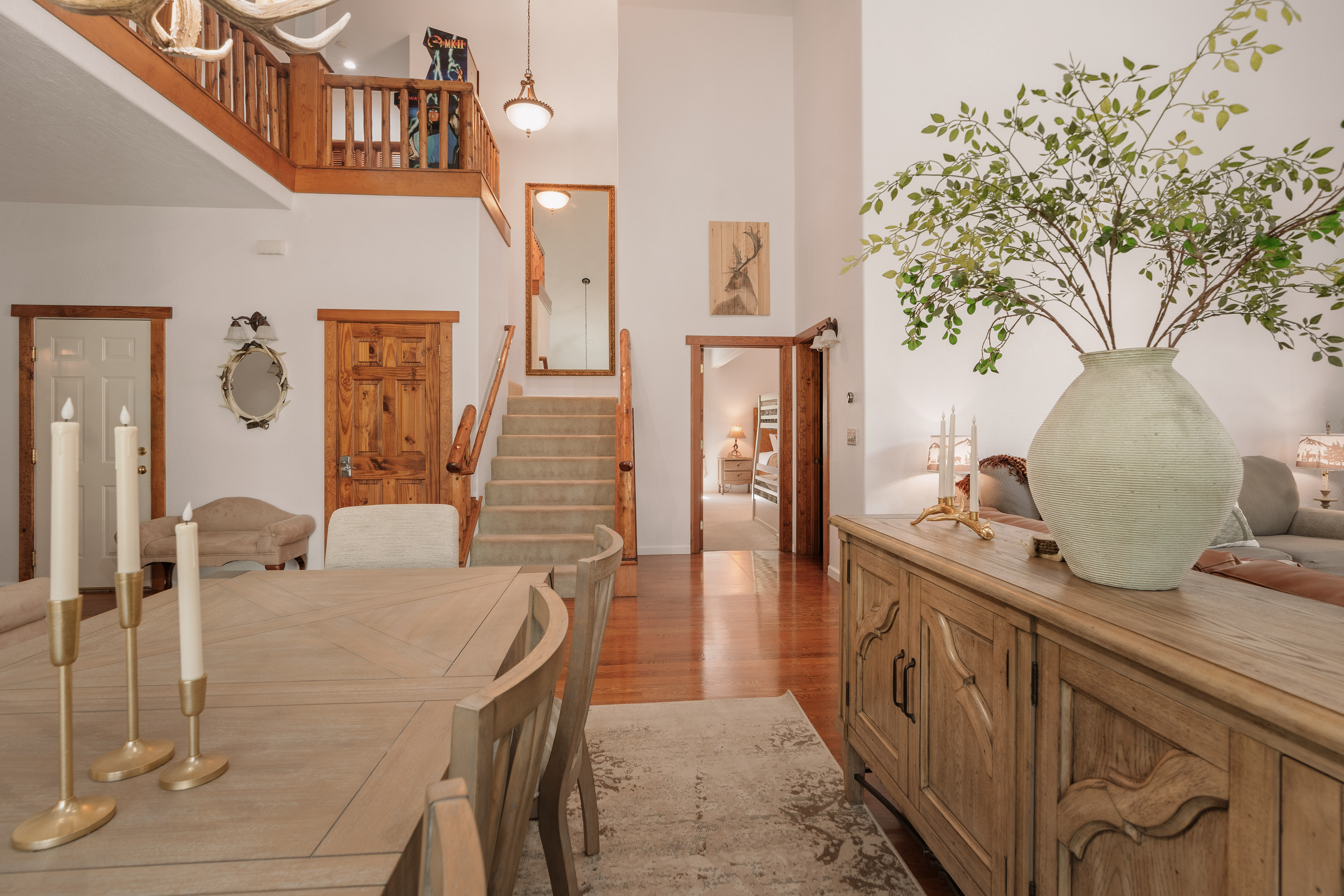 Bright vaulted entry with rustic dining area and charming loft overlook