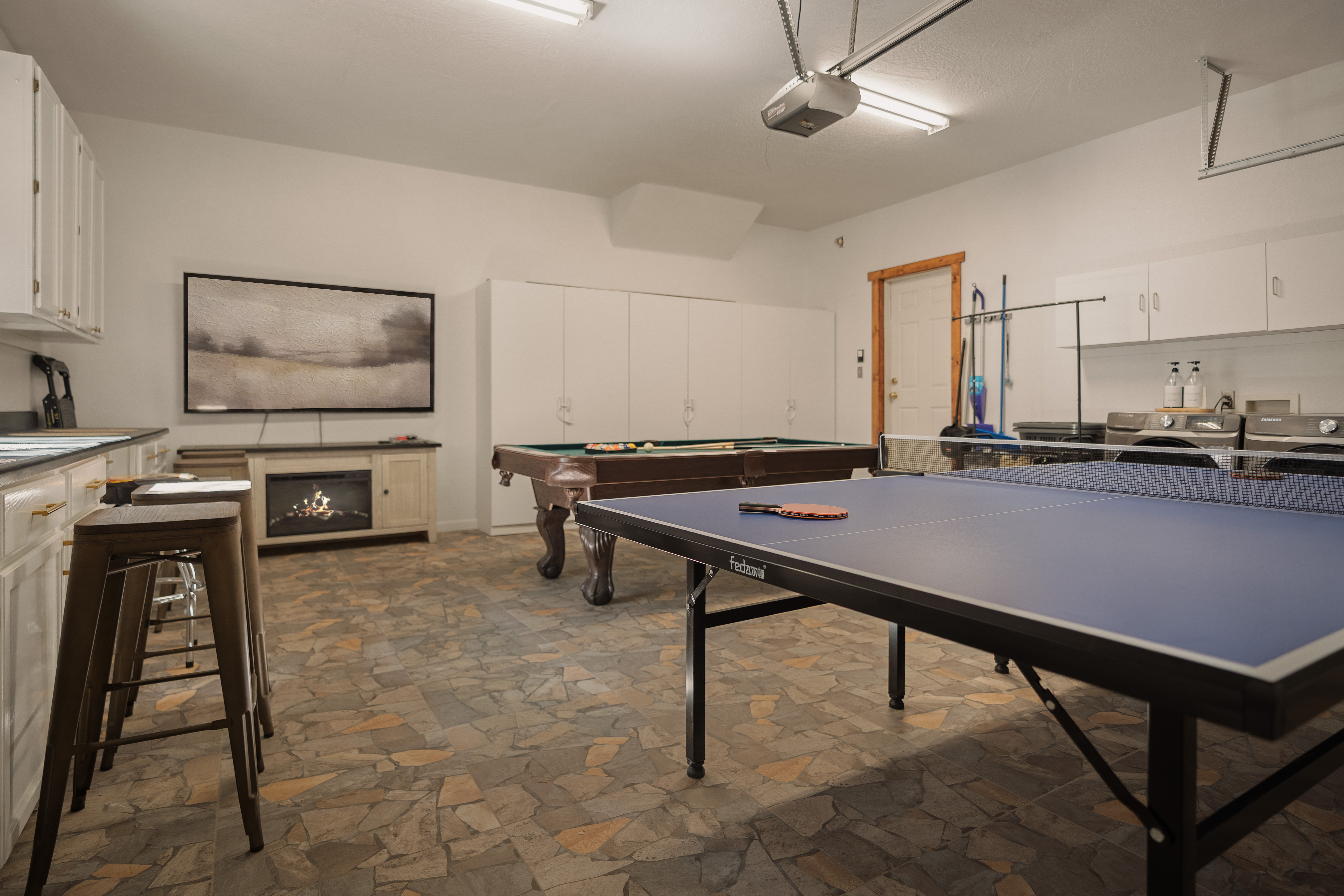 Spacious game room with ping pong, pool table, and cozy fireplace