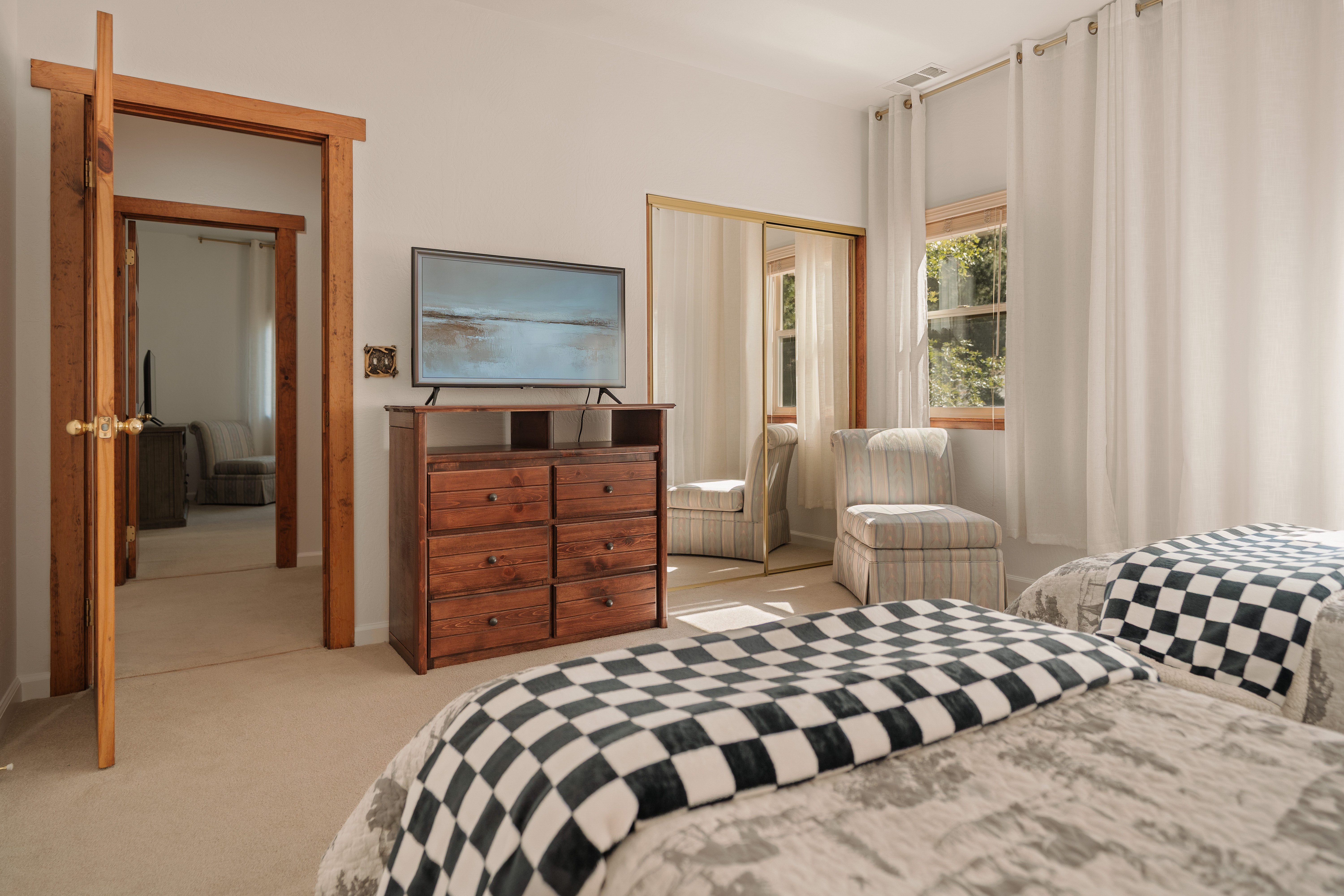 Bright twin bedroom with TV, natural light, and cozy seating