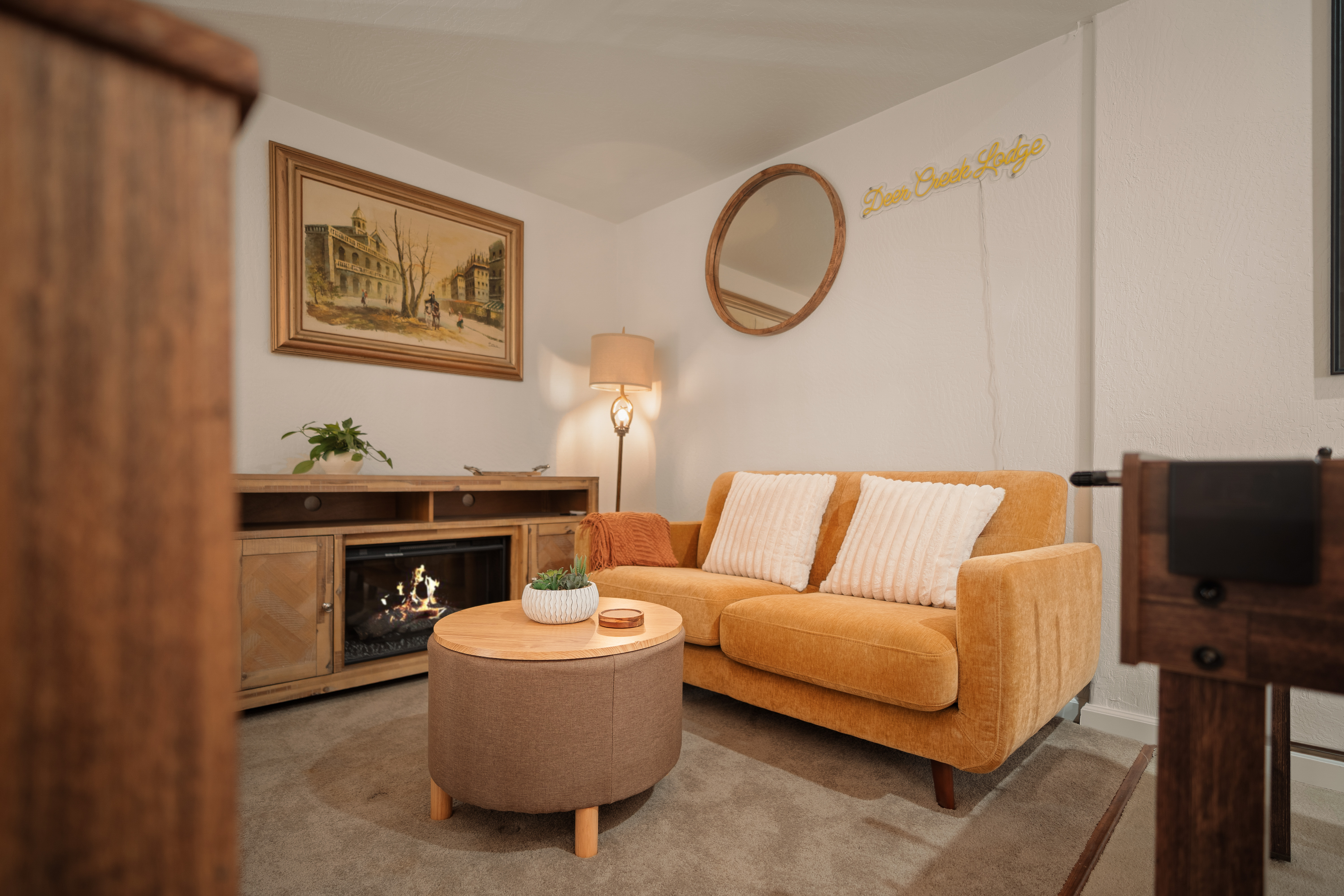Cozy lounge with fireplace, mustard sofa, and warm inviting decor
