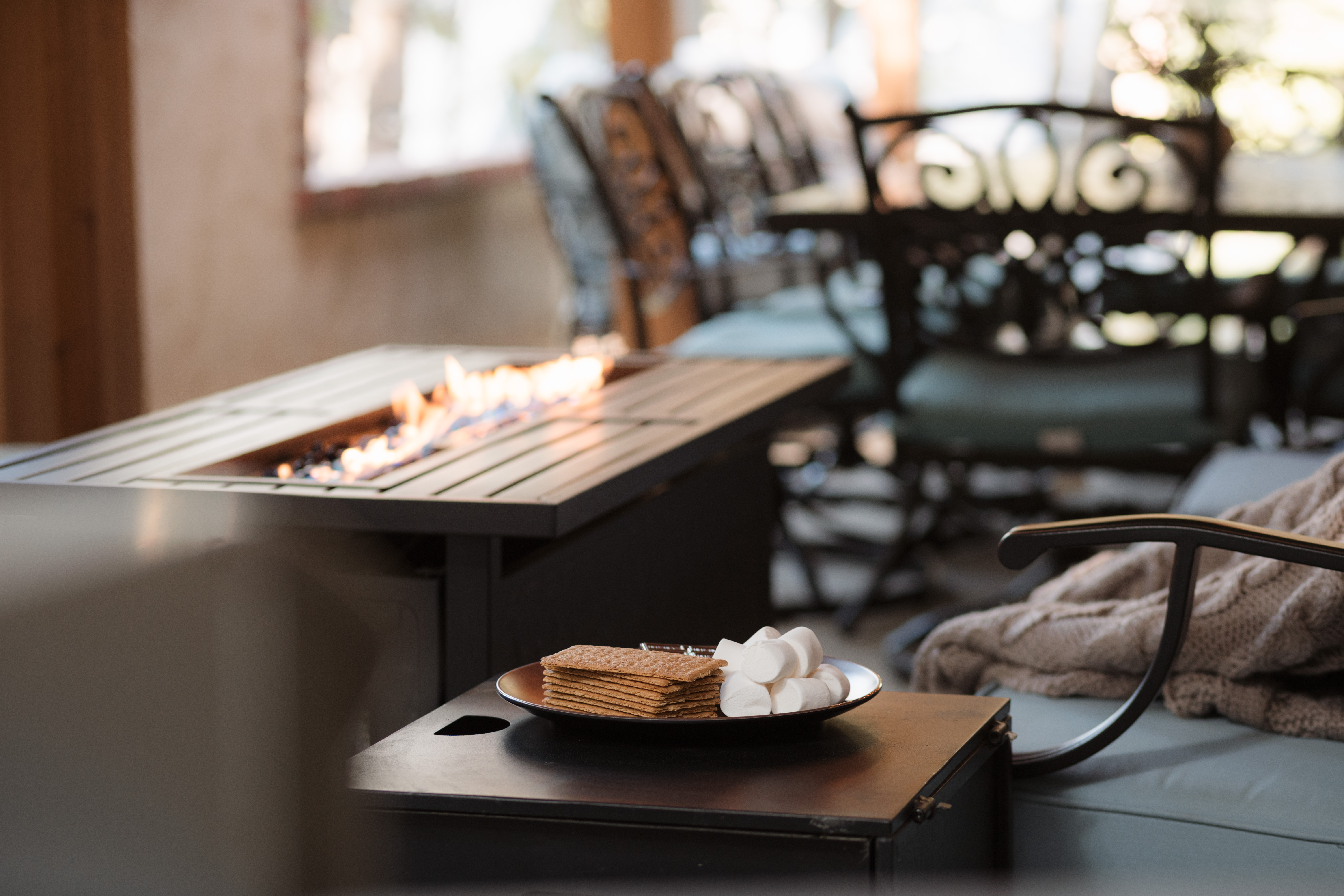 Cozy patio fire table with s’mores setup and inviting lounge seating